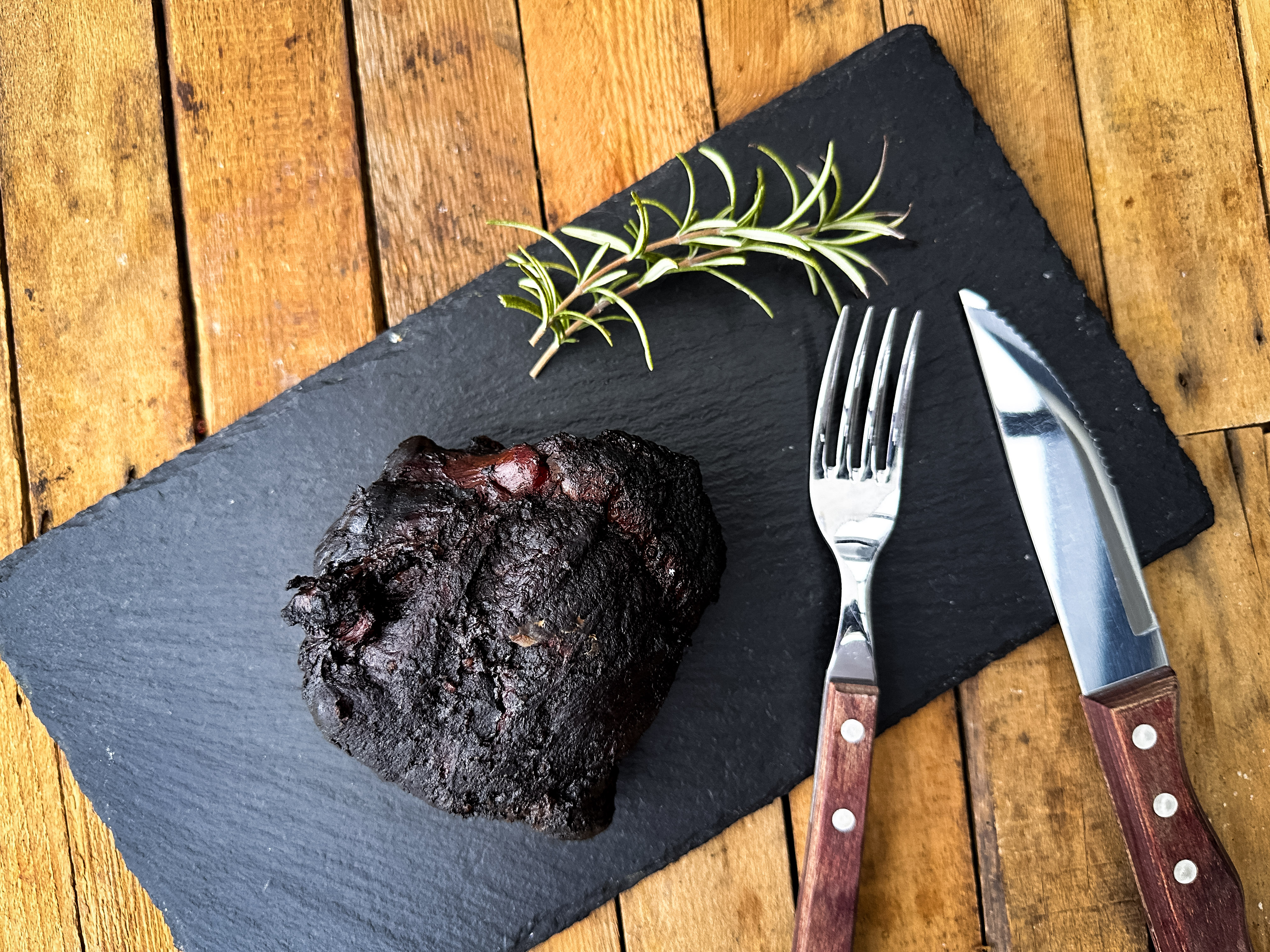 Zart geschmorte Kalbsbacken vom Oberpfälzer Milchkalb – regionales Gourmetfleisch kaufen Zart geschmorte Kalbsbäckchen vom Oberpfälzer Milchkalb auf dunkler Soße, angerichtet mit cremigem Kartoffelpüree und glasierten Möhren, serviert auf einem weißen Teller vor dunklem Hintergrund.