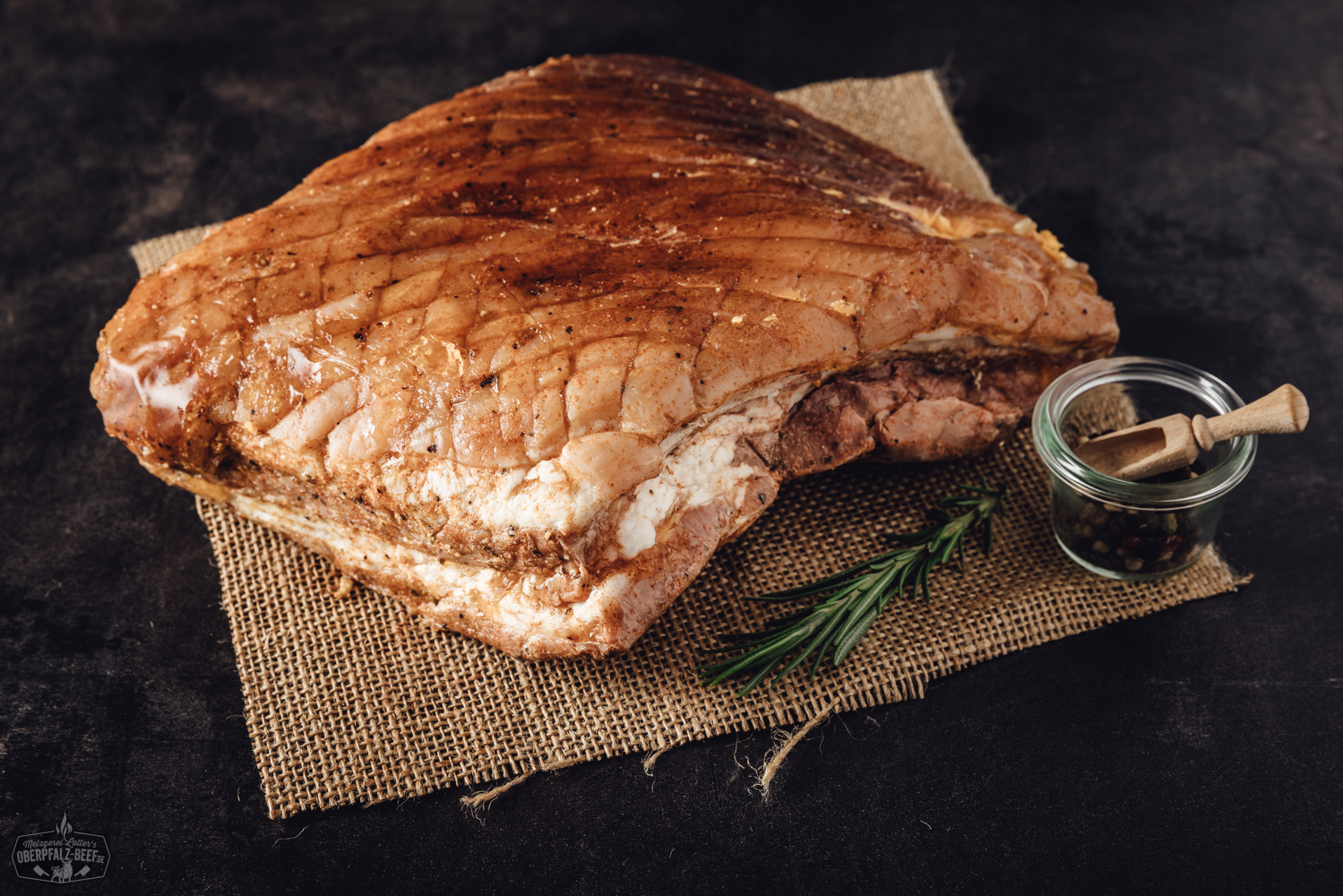 Sous-vide gegarter Krustenbraten vom Schweinebauch mit krosser Kruste auf Schneidebrett Ein köstlicher, sous vide vorgegarter Krustenbraten vom Schweinebauch mit knuspriger Kruste auf einem rustikalen Holzbrett präsentiert.
