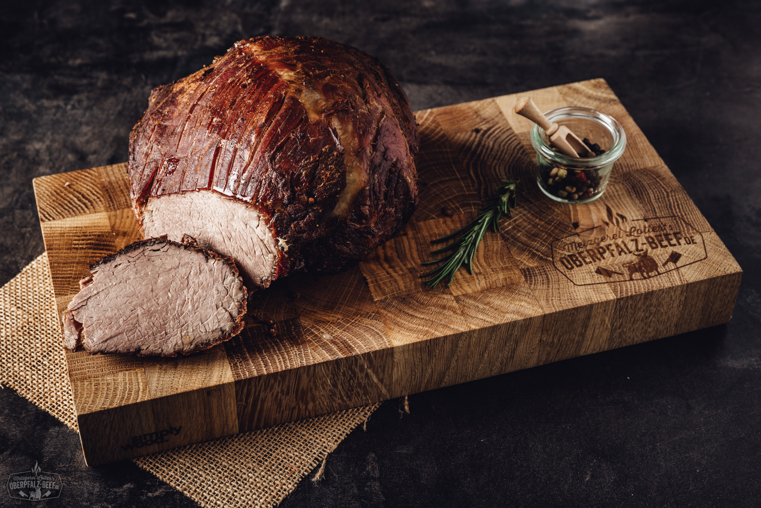 Sous-vide vorgegarter Kalbsbraten aus der Nuss – zartes Premiumfleisch für Genießer Aufgeschnittener, saftiger Rinderbraten aus der Keule, sous-vide vorgegart, auf einem Holzbrett angerichtet mit dunkler Bratensoße und frischen Kräutern, im rustikalen Stil präsentiert.