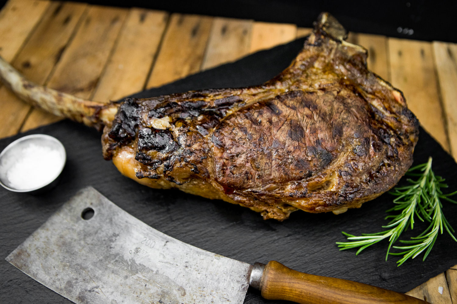 Tomahawk Cut vom Oberpfalz Rind – Dry Aged Premium Steak zum Selberreifen Rohes Tomahawk-Steak vom Oberpfalz-Rind auf dunklem Untergrund, mit sichtbarem langen Knochen und gut marmorierter Fleischstruktur, ideal zum Reifen oder Grillen.