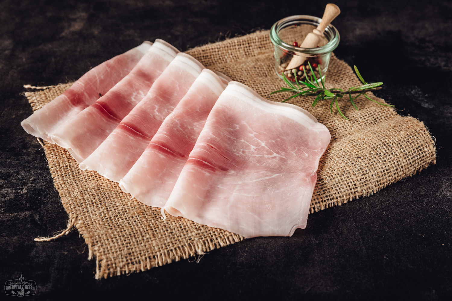 Geschnittener Kochschinken aus der Oberpfalz – Frischer Aufschnitt in Premiumqualität Geschnittener Kochschinken in zarten, rosa Scheiben appetitlich auf einem Holzbrett angerichtet, garniert mit frischer Petersilie – ideal für Brotzeit, Frühstück oder Sandwiches.