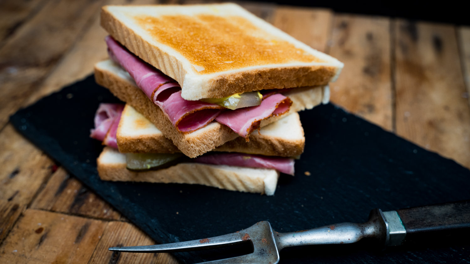 Pastrami Oberpfalz Style geschnitten – Regionales Rindfleisch fein aufgeschnitten Geschnittenes Pastrami im Oberpfalz-Style, saftig und zartrosa, auf einem Holzbrett angerichtet mit sichtbarem Gewürzrand und zarter Marmorierung – traditionelles bayerisches Rindfleisch-Delikatessprodukt für Feinschmecker.