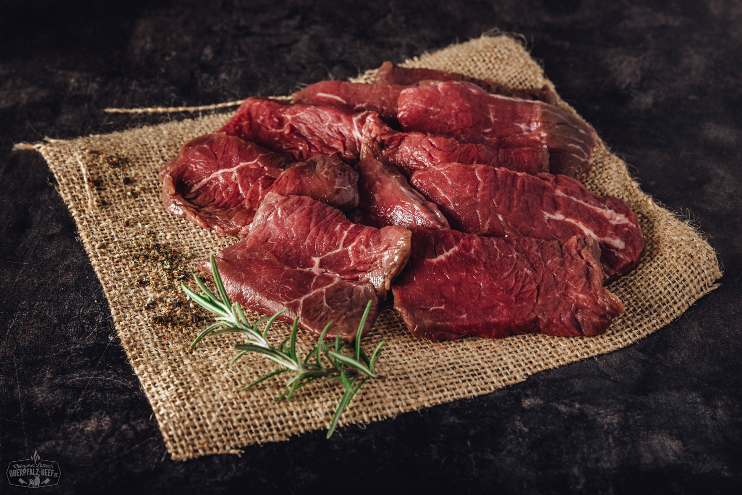 Handgeschnittenes Rinderhüftfleisch für Raclette – Premiumqualität aus der Oberpfalz Raclette-Fleisch vom Rind: Handgeschnittene, zarte Rinderhüfte auf schwarzem Teller angerichtet – saftig marmoriert, ideal portioniert für Raclette oder Grill. Hochwertiges Beef, frisch und nachhaltig aus der Oberpfalz.