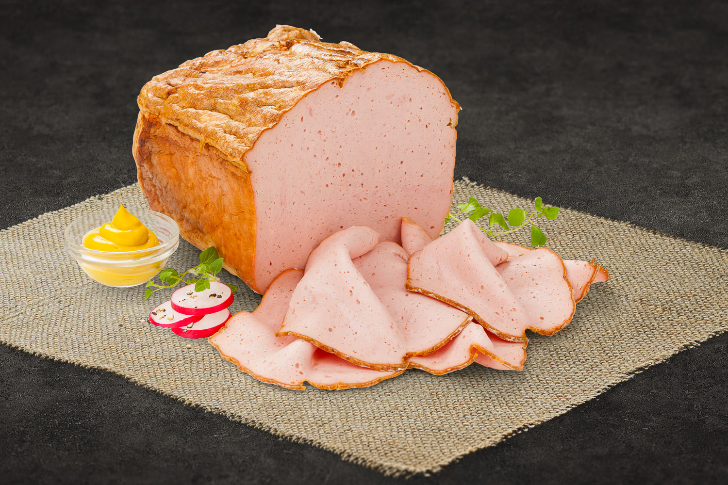 Mehrere Scheiben frischer, gebratener Leberkäse mit goldbrauner Kruste auf einem Holzbrett angerichtet, im Hintergrund eine rustikale Tischdecke – typisch bayerische Spezialität.