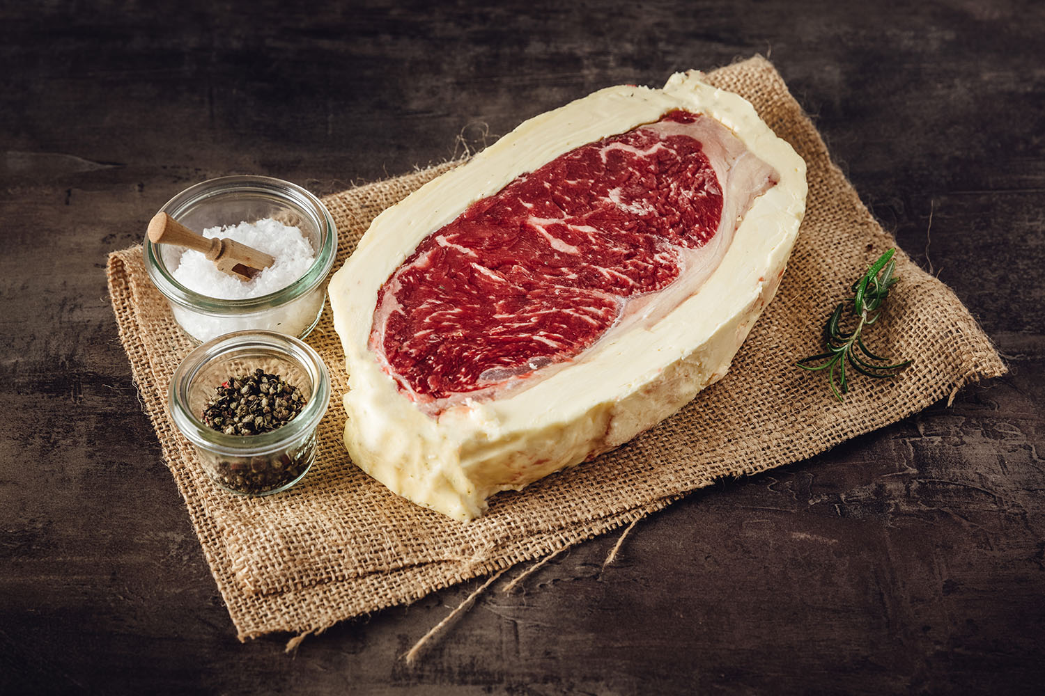 Roastbeef Steak mit Kräuterbutter vom Oberpfalz-Rind – Dry Aged Fleisch in Premium-Qualität Roastbeef-Steak vom Oberpfalz-Rind, medium gebraten, mit sichtbarer Marmorierung und goldbrauner Kruste, serviert mit einem Stück Butter und Kräutergarnitur auf Holzbrett – hochwertige Dry-Aged Fleischspezialität.