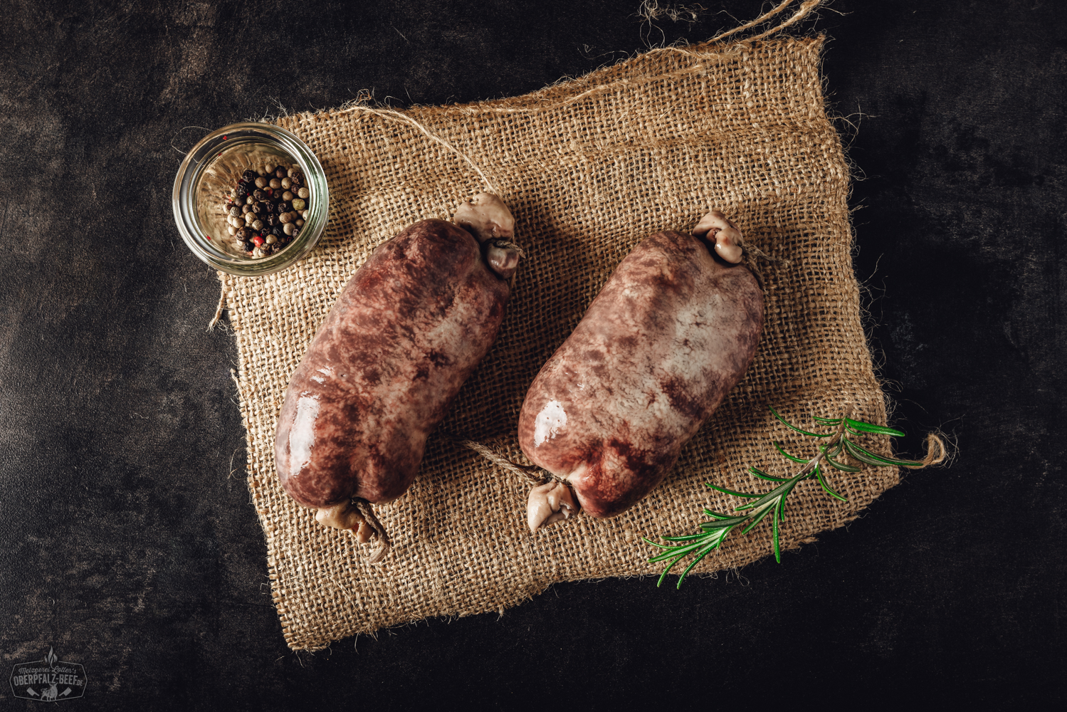 Frische Blutwurst vom Metzger – Hausgemacht und regional Frische rohe Krautwurst auf Holzbrett, umgeben von Zwiebeln, Kraut und Gewürzen, traditionelle bayerische Spezialität aus der Oberpfalz.
