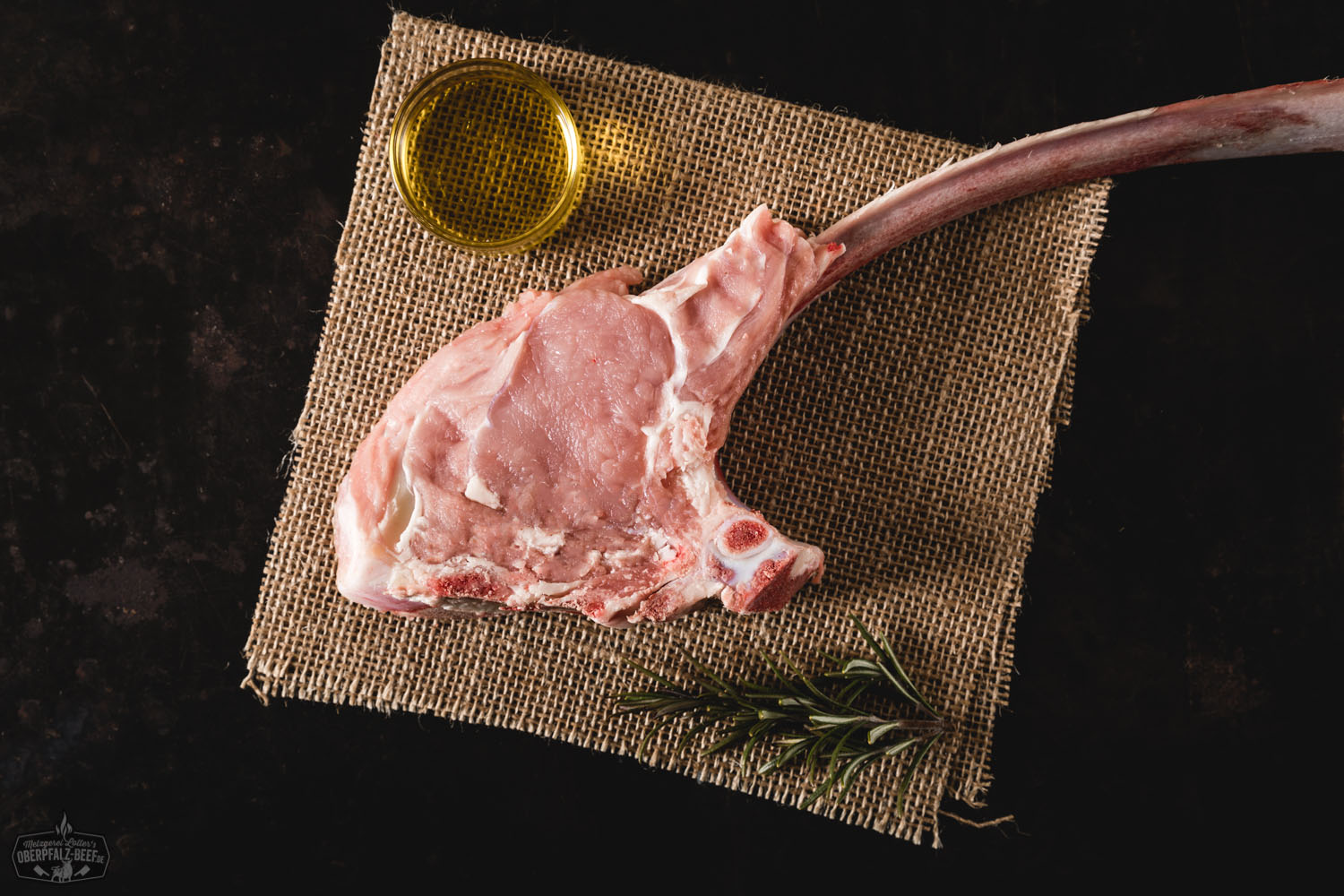 Tomahawksteak vom Oberpfälzer Milchkalb, dry aged, saftig und zart, verführerisch im Bild präsentiert auf einem Holzbrett.