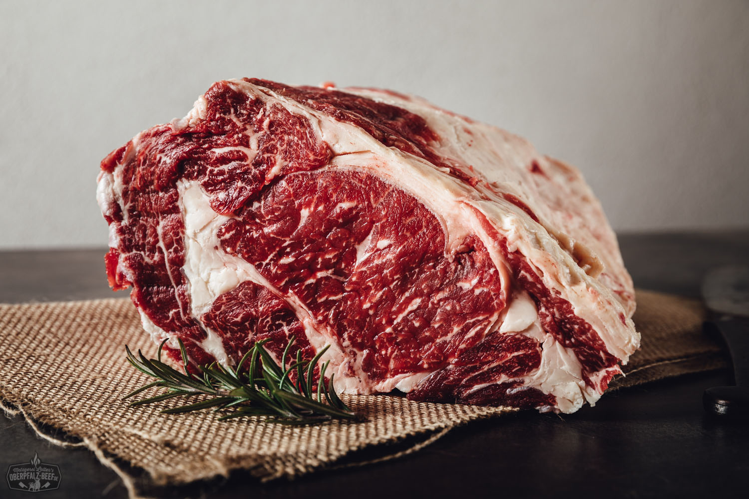 Entrecôte ohne Knochen vom Oberpfalz-Rind – perfekt zum Selberreifen Rohes Entrecôte-Rib-Eye-Steak ohne Knochen vom Oberpfalz-Rind auf schwarzem Untergrund, mit sichtbarer feiner Marmorierung und Fettdeckel – hochwertige Fleischqualität zum Selbstreifen.