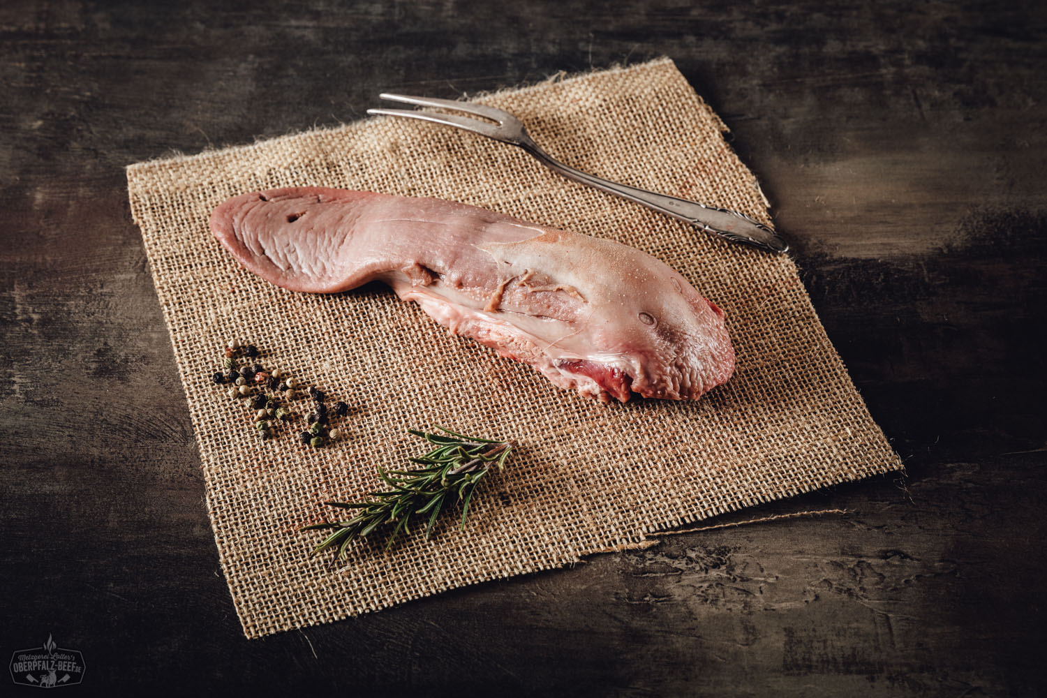 Frisch gegarte Schweinezunge auf Holzbrett angerichtet, im Anschnitt sichtbar zart und saftig, mit Petersiliengarnitur – traditionelle Delikatesse aus der Oberpfalz.