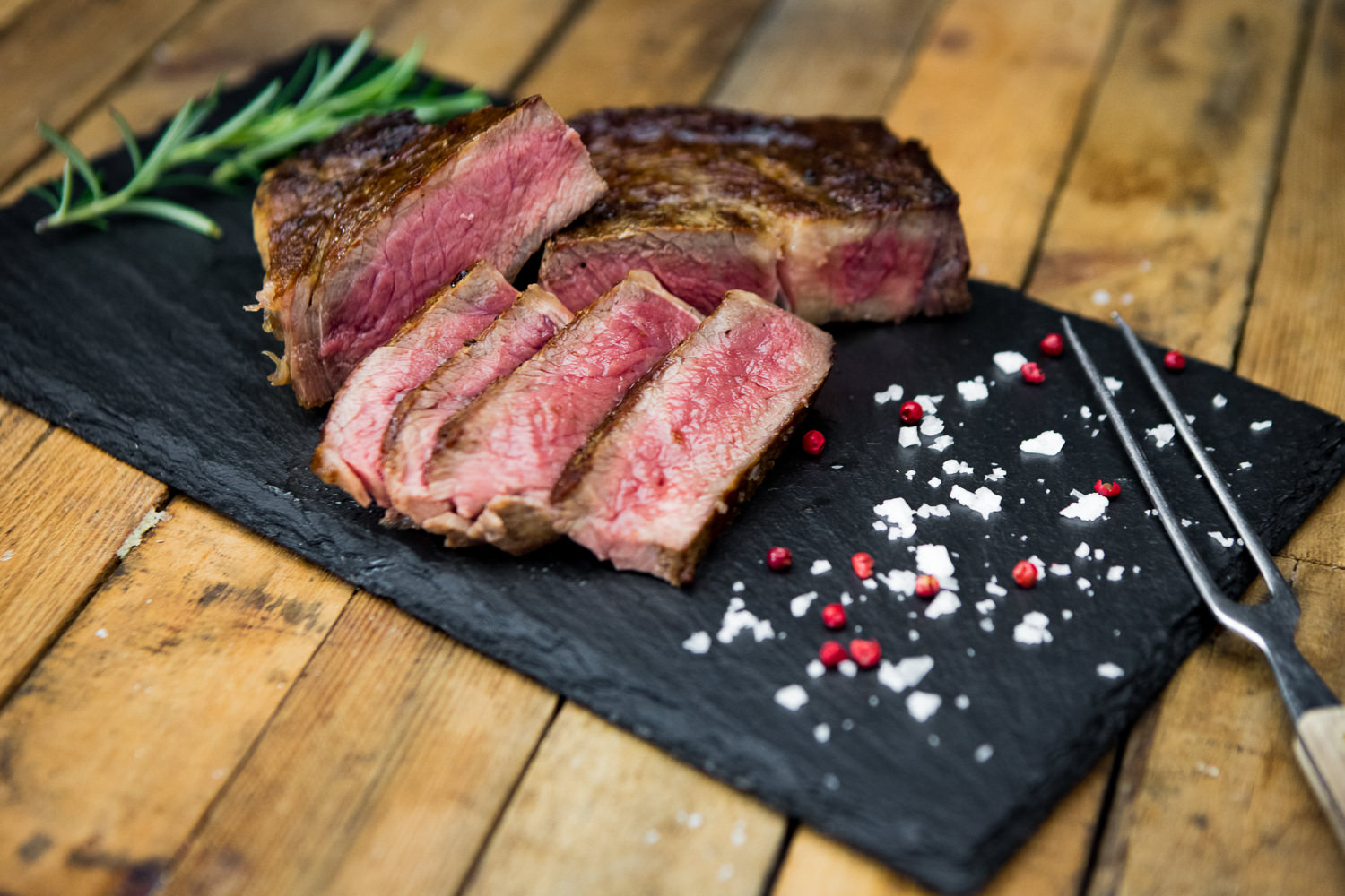 Entrecôte am Stück – Wet Aged Rib-Eye vom Oberpfalz-Rind Roastbeef am Stück vom Oberpfalz-Rind, Wet Aged gereift, roh und quer aufgeschnitten, auf schwarzem Untergrund präsentiert – gut marmoriertes Rindfleisch in Premiumqualität für Steak, Braten oder Grillgerichte.