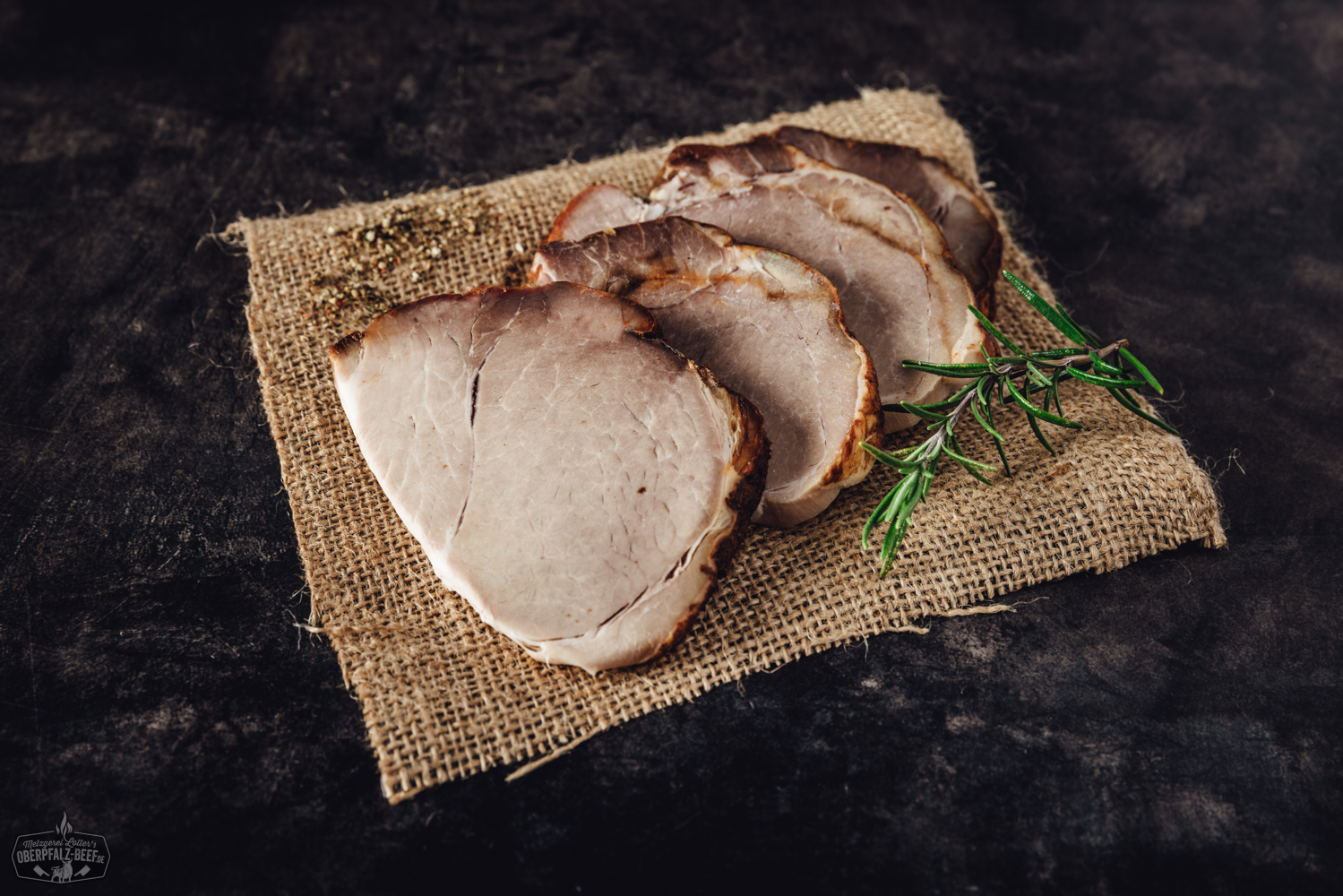 Sous-vide gegarter Schweinebraten – zartes Fleisch in perfekter Portion Vorgarer Rinderbraten vom Oberpfalz-Rind, in Scheiben geschnitten und saftig angerichtet auf einem weißen Teller, begleitet von Rosmarin und einer dunklen Soße – ideal für Sous-vide-Zubereitung, hochwertiges Rindfleisch aus der Oberpfalz.
