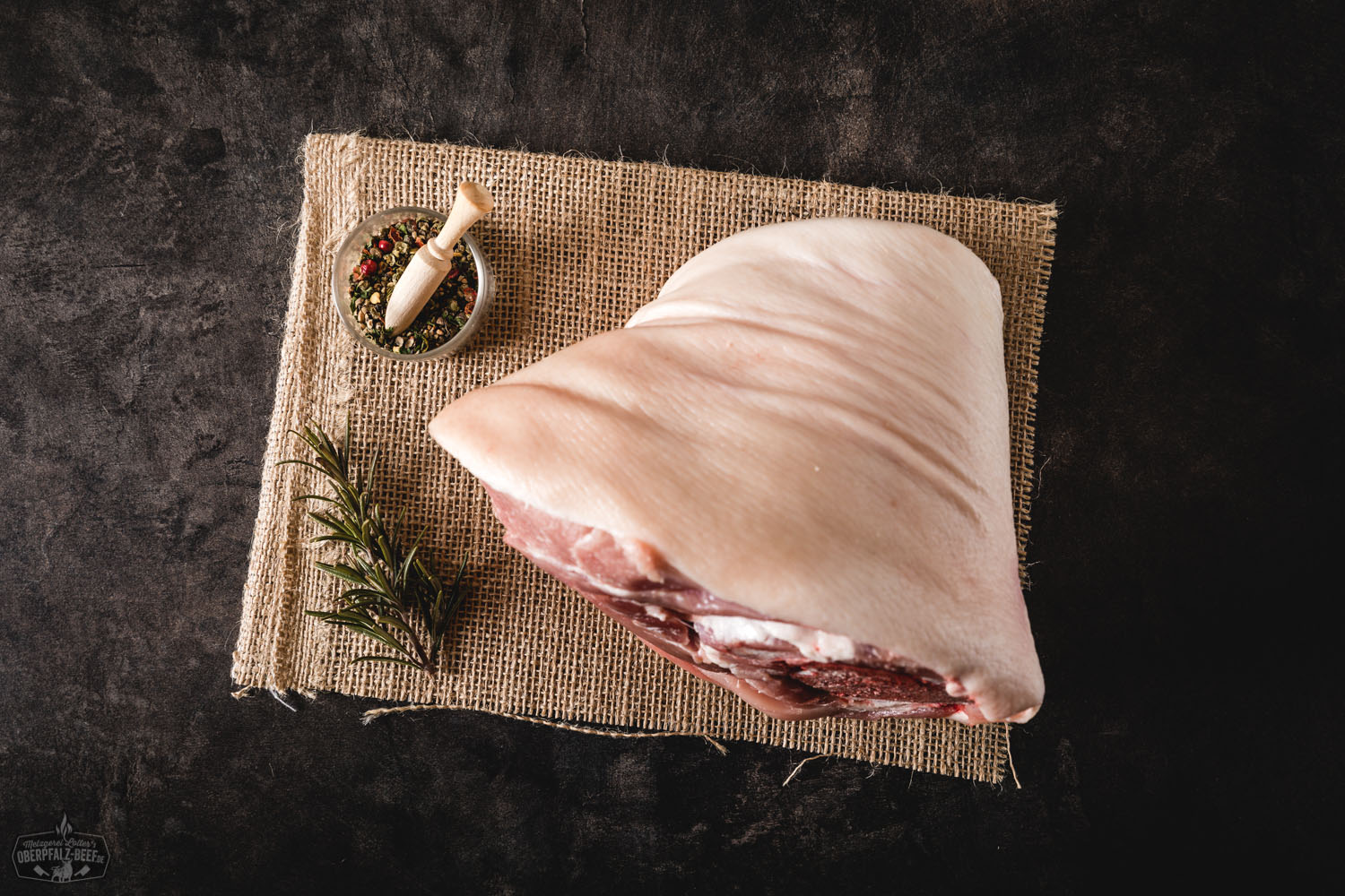Hintere Haxe vom Oberpfälzer Landschwein – Regionales Schweinefleisch kaufen Rohe hintere Schweinshaxe vom Oberpfälzer Landschwein auf hellem Untergrund, marmoriert mit sichtbarer Haut und Knochen, ideal für traditionelle Schmorgerichte wie Schweinshaxe oder Eisbein.