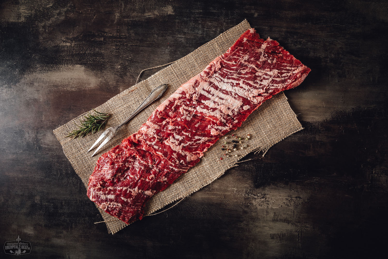 Inside Skirt Wet Aged vom Oberpfalz-Rind – zart gereiftes Rindfleisch in Premiumqualität Rohes Inside Skirt Steak vom Oberpfalz-Rind, wet-aged gereift, auf dunklem Untergrund präsentiert mit sichtbarer Marmorierung und frischen Kräutern – hochwertiges Rindfleisch für BBQ und Steakliebhaber.