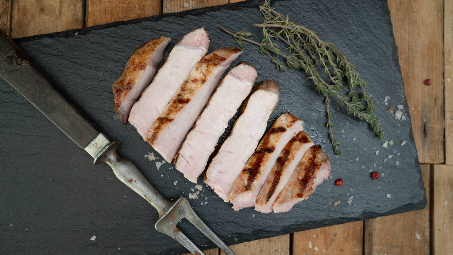 Metzgerkotelett vom Oberpfälzer Landschwein – Frisches Premium-Schweinefleisch aus Bayern Rohes Metzgerkotelett vom Oberpfälzer Landschwein auf dunklem Untergrund, mit gut sichtbarem Knochen, kräftiger Marmorierung und frischem Fettrand – hochwertiges Schweinefleisch für Grill oder Pfanne.