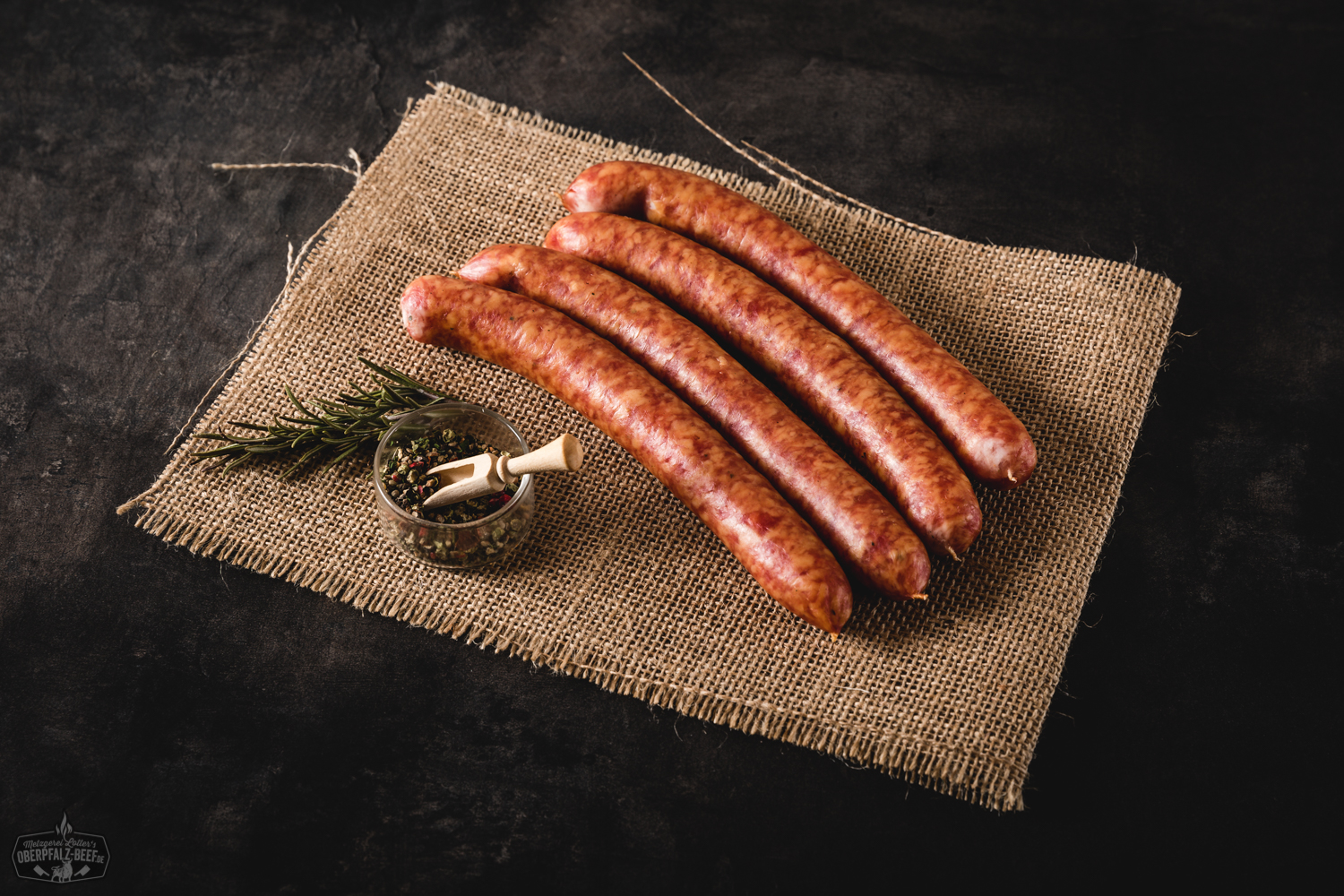 Pfefferbeißer Würstchen aus der Oberpfalz – herzhaft geräuchert und regional gefertigt Aromatische Pfefferbeißer Wurst aus Oberpfalz Beef auf einem rustikalen Holztisch platziert, perfekt zur Brotzeit und für Liebhaber würziger Fleischspezialitäten.