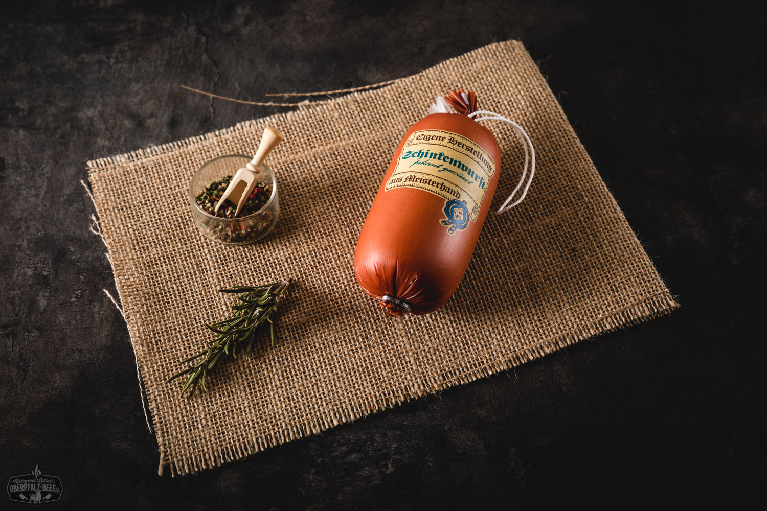 Feine Schinkenwurst in Portionsgröße – Delikatesswurst aus Bayern Feine Schinkenwurst in Portionsgröße, einzeln verpackt in transparenter Folie mit Etikett von Oberpfalz Beef, auf hellem Untergrund platziert – Wurst mit sichtbaren Fleischstücken, ideal für Brotzeit, Delikatessen oder regionale Spezialitäten.