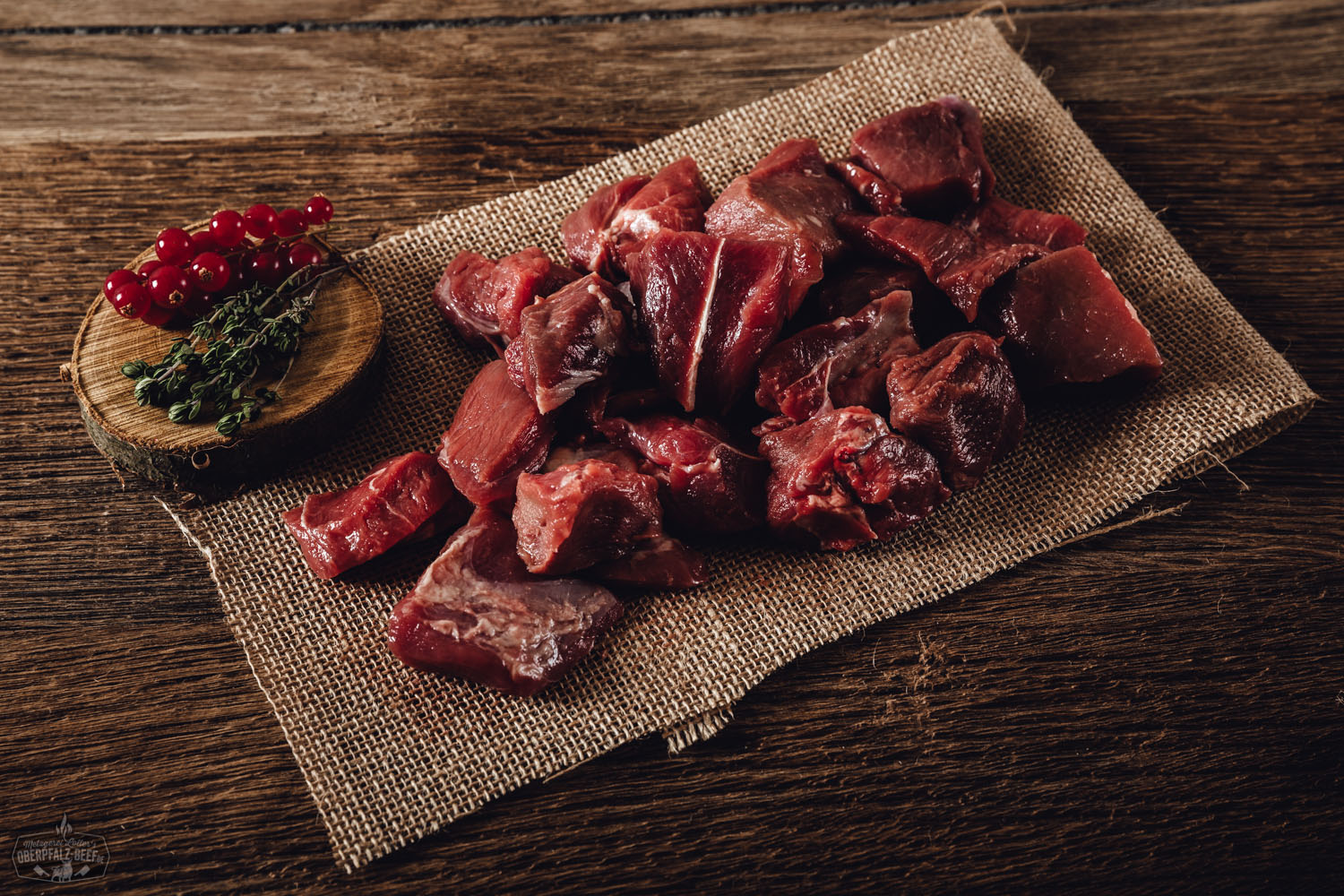 Edelgulasch vom Oberpfälzer Wildschwein – Regionales Wildfleisch in Premiumqualität Rohes Edelgulasch vom Oberpfälzer Wildschwein auf dunklem Untergrund angerichtet, mit frischen Rosmarinzweigen, Pfefferkörnern und Meersalz garniert – hochwertiges Wildfleisch aus regionaler Herkunft.