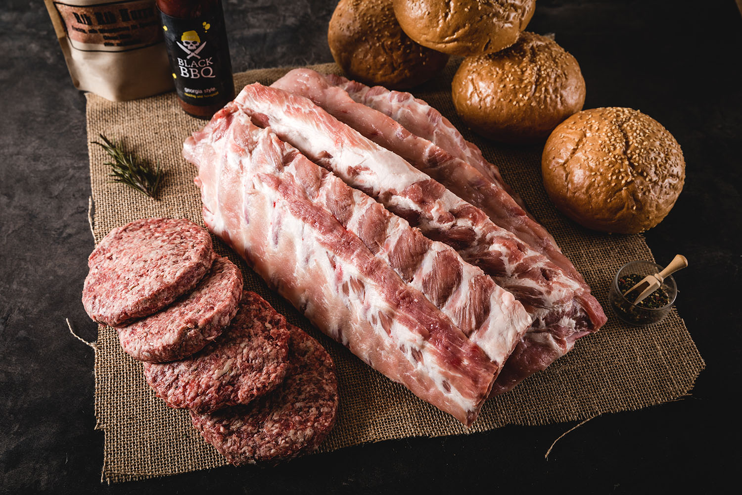 Baby Back Ribs und Burger Paket von Oberpfalz Beef – Premium BBQ Fleisch im Set Zwei saftige Burger mit Baby Back Ribs, belegt mit Salat, Tomaten, Gurken und BBQ-Sauce, serviert auf einem Holzbrett mit Pommes frites, Krautsalat und Dip – hochwertiges BBQ-Burger-Paket von Oberpfalz Beef.