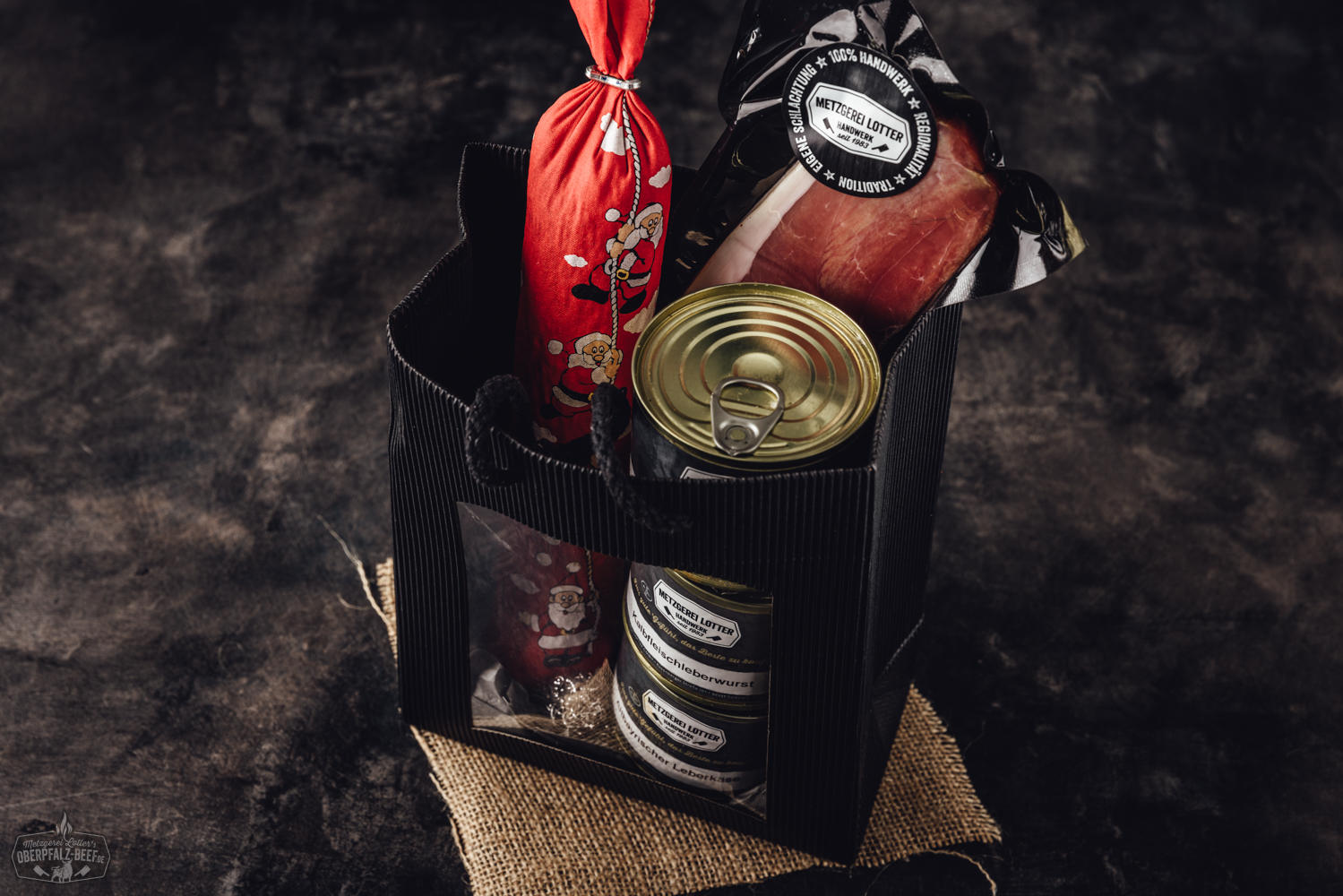 Geschenktasche mit regionalen Fleischspezialitäten aus der Oberpfalz – Festtagspaket für Genießer Grob geschnittener Putenleberkäse auf einem Holzbrett angerichtet, begleitet von frischen Petersilienblättern und Gewürzen – herzhafte Wurst-Spezialität aus der Oberpfalz.