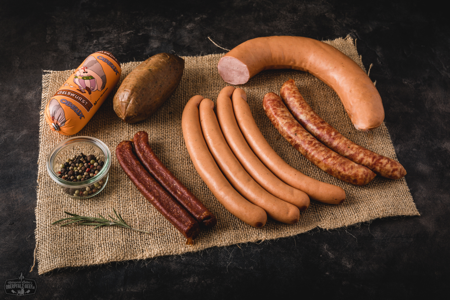 Notfallpaket Wurst – Hausgemachte Dosenwurst aus der Oberpfalz kaufen Bild eines Notfallpakets mit verschiedenen Arten von Wurst, das vakuumverpackt und auf einer rustikalen Holzoberfläche präsentiert wird, ideal für Liebhaber von Oberpfälzer Fleischspezialitäten.