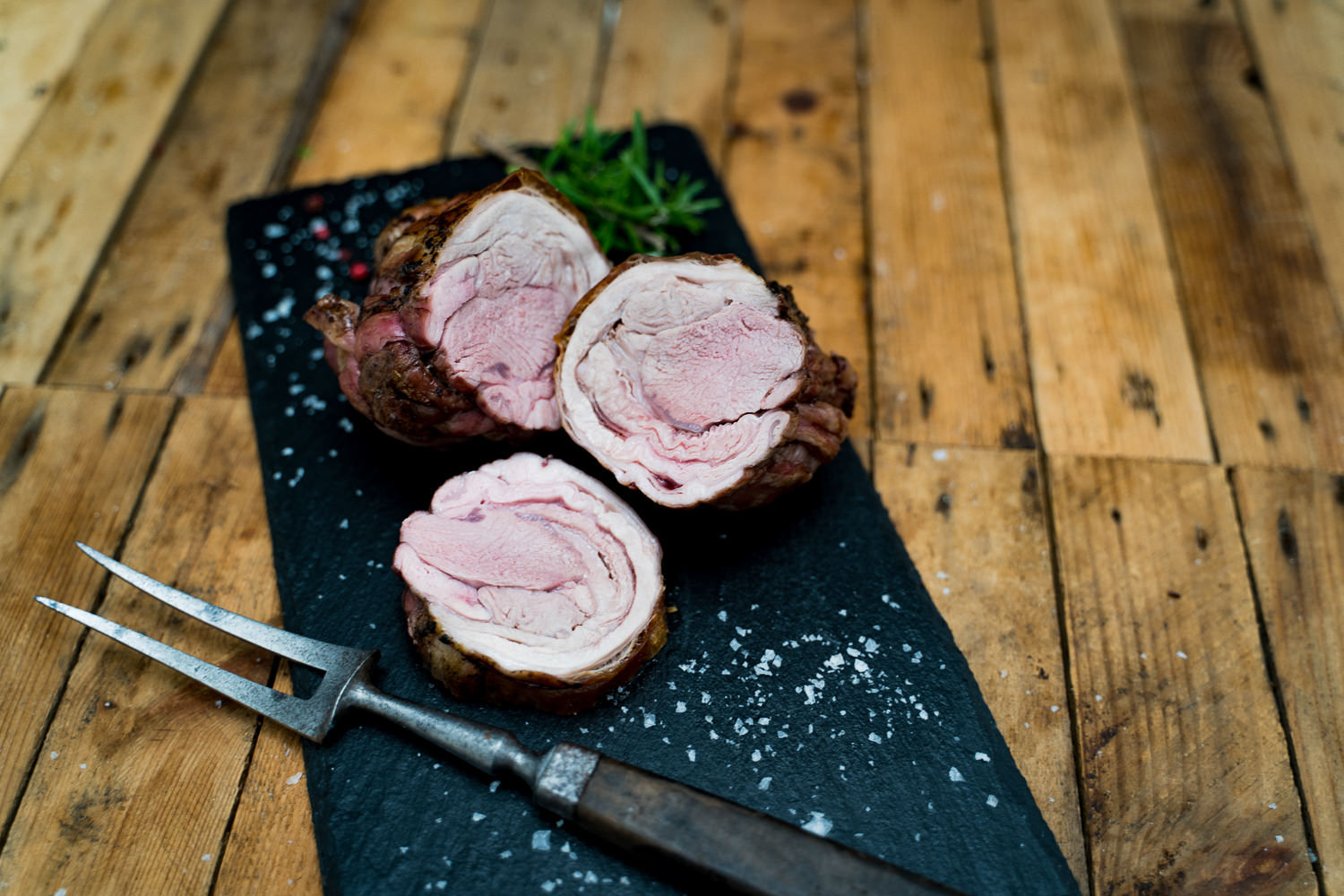 Lammhals mit Knochen vom Juradistl Lamm – Frisches Weidefleisch aus der Oberpfalz Rohes Lammhals-Stück mit Knochen vom Juradistl-Lamm auf dunklem Untergrund, saftig marmoriert, frisch zugeschnitten – ideales Fleischstück für Schmoren oder Braten.