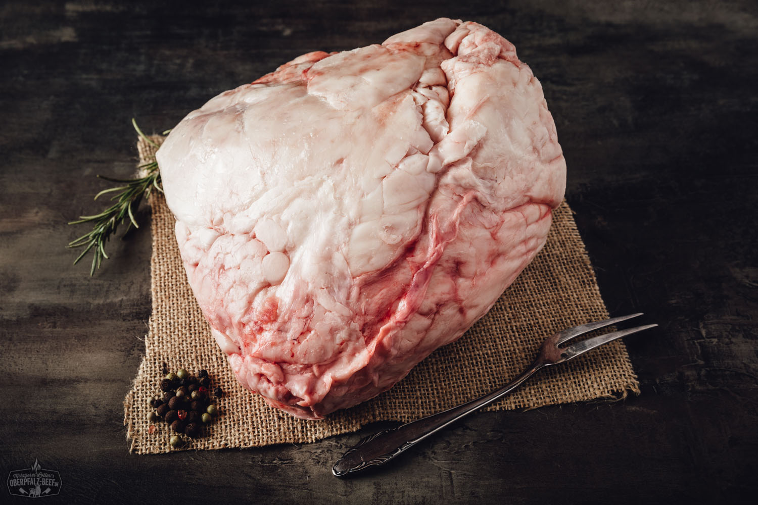 Frisch geschnittenes Rindertalg vom Oberpfalz-Rind auf dunklem Untergrund, naturbelassen präsentiert mit goldbraunen Fettstücken – hochwertige Zutat für traditionelles Kochen und Braten.