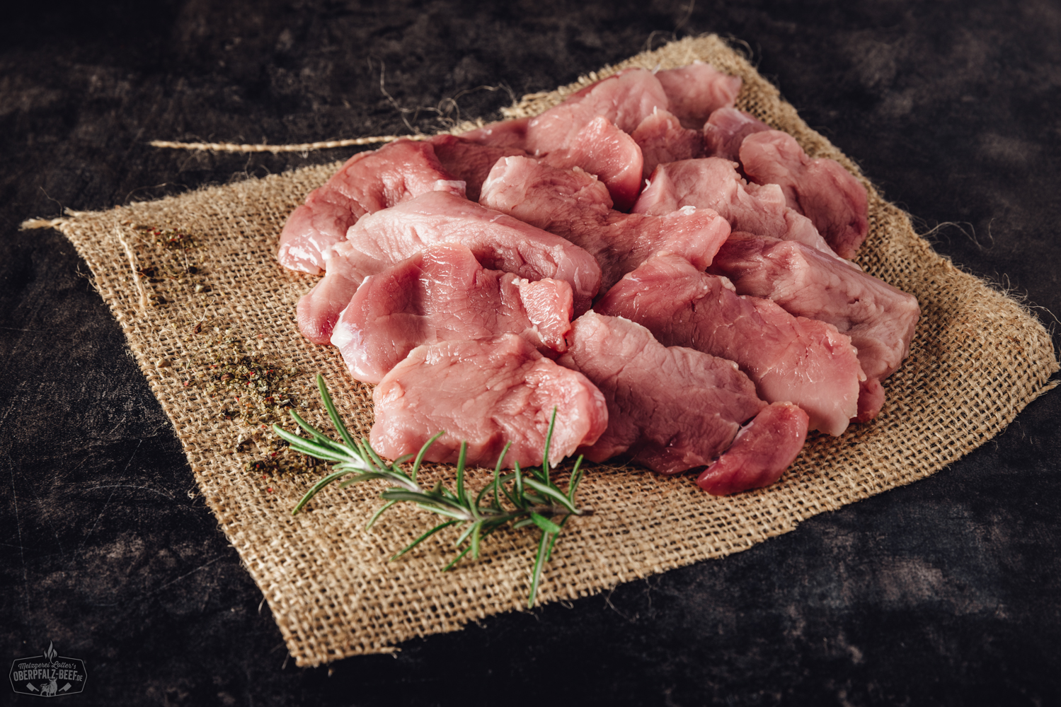 Handgeschnittenes Schweinefilet für Raclette – zartes Premiumfleisch aus der Oberpfalz Handgeschnittenes Schweinefilet für Raclette, roh und zart rosa, in feine Scheiben geschnitten und übereinandergelegt auf einem dunklen Untergrund, ideal für Raclette oder Grillgerichte.