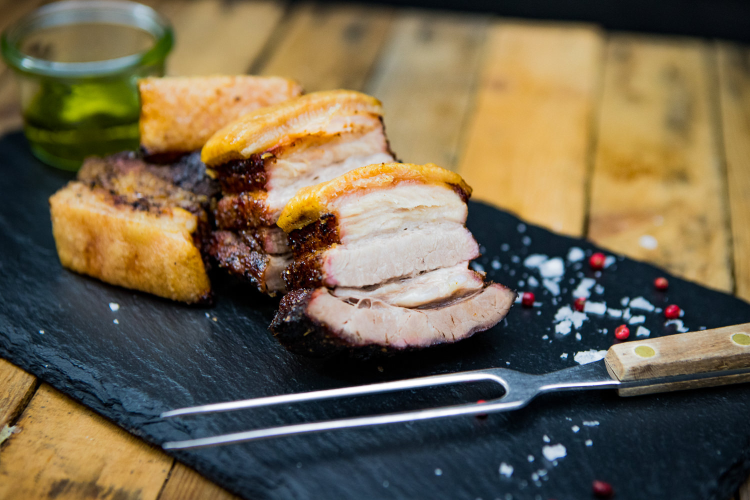 Bauch ohne Knochen vom Oberpfälzer Landschwein – Frisches Schweinefleisch in Premiumqualität Fein geschnittener Trüffelschinken auf dunklem Holzbrett angerichtet, mit sichtbaren Trüffelstückchen im zarten, marmorierten Fleisch; im Hintergrund ein Messer – hochwertige Delikatesse für Feinschmecker.
