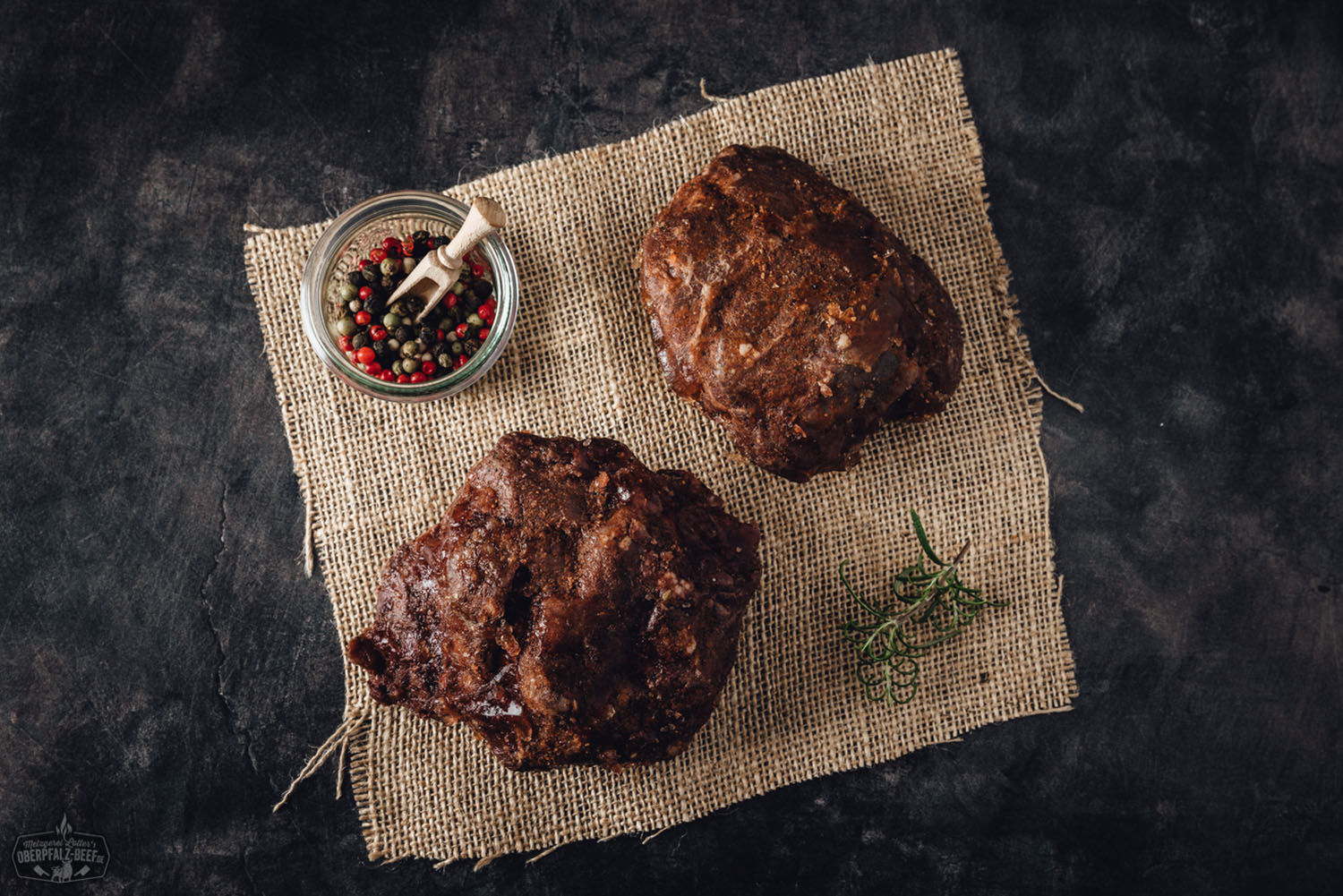 Zart gegarte Ochsenbacke sous-vide auf Holzbrett angerichtet Zart geschmorte Ochsenbacke, sous-vide vorgegart, serviert mit dunkler Bratensauce auf einem weißen Teller, garniert mit frischen Kräutern – hochwertige Fleischspezialität aus der Oberpfalz.
