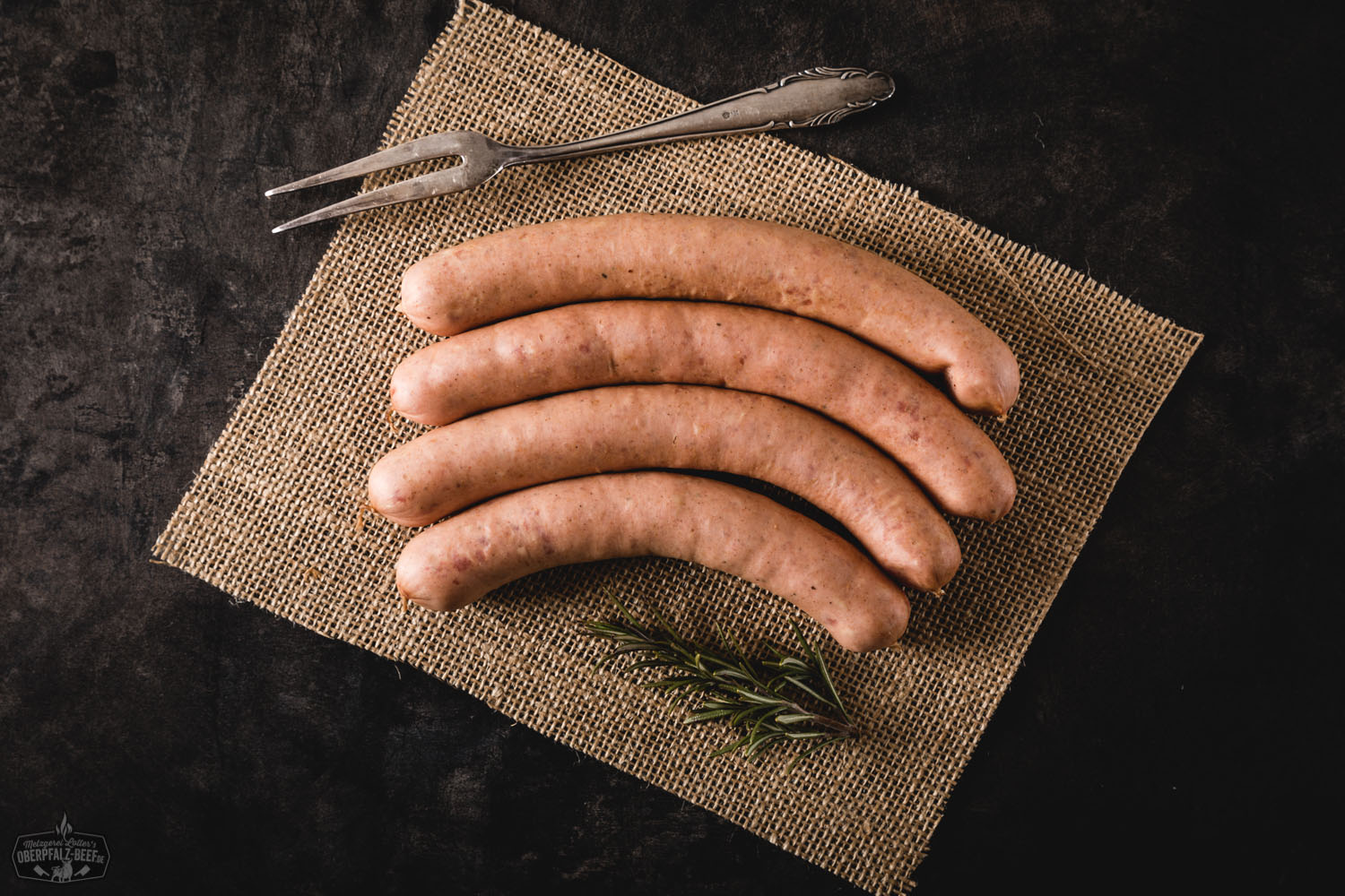 Käsegriller vom Grill – Saftige Bratwürste mit geschmolzenem Käsekern Nahaufnahme von fünf gegrillten Käsegrillern mit goldbrauner, knuspriger Haut und sichtbar geschmolzenem Käse in den Anschnitten, serviert auf einem dunklen Holzbrett mit rustikalem Hintergrund – herzhafte Bratwurst-Delikatesse typisch für die Oberpfalz.