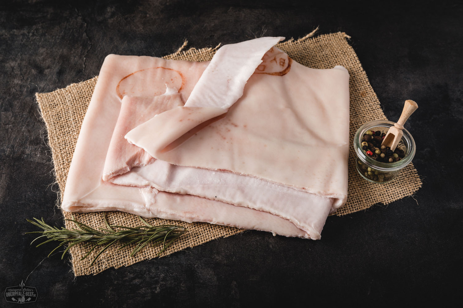 Frische Schweineschwarte vom Oberpfälzer Landschwein – Regionales Qualitätsfleisch Frische, rohe Schweineschwarte vom Oberpfälzer Landschwein auf Holzbrett, leicht eingeritzt, mit sichtbarer Fettstruktur – ideales Ausgangsprodukt für knusprige Kruste oder Schmalz, regional aus artgerechter Haltung.