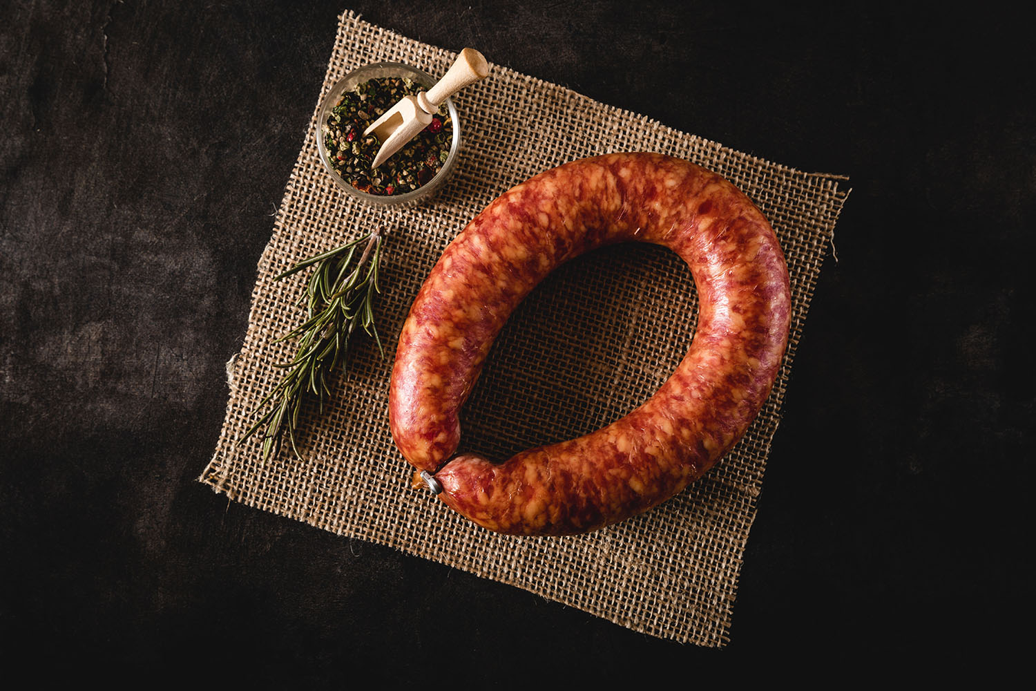 Geräucherte Oberpfälzer Bauernbratwurst im Ring – Traditionelle Delikatesse aus Bayern Geräucherte Oberpfälzer Bauernbratwurst im Ring auf Holzbrett angerichtet, dunkelbraune, glänzende Oberfläche mit natürlicher Krümmung, im Hintergrund traditionelle Dekoration und Brot – typisch bayerische Spezialität.