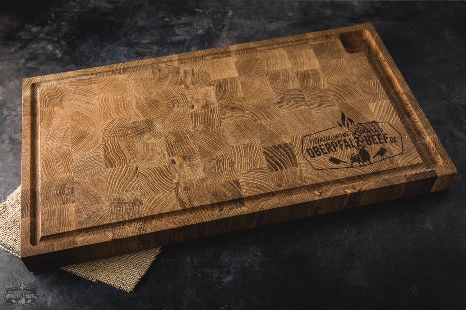 Grill- und Kochbrett aus massivem Eichenholz im Oberpfalz Beef Style Rustikales Schneidebrett aus massivem Eichenholz im Oberpfalz Beef Style mit eingebranntem Logo, auf Holztisch präsentiert – ideal zum Grillen und Kochen, handgefertigt für BBQ-Enthusiasten.