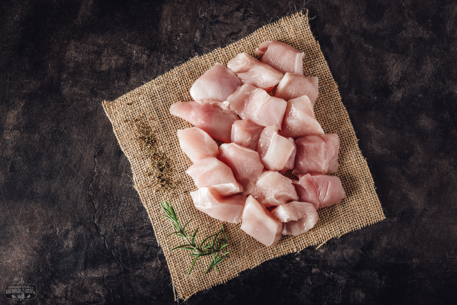 Handgeschnittenes Hähnchenbrustfilet für Fondue – Frisch & mager aus der Oberpfalz Handgeschnittenes Fondue-Fleisch aus Hähnchenbrust, roh und in gleichmäßige Streifen geschnitten, frisch angerichtet auf einem hellen Teller mit Kräutergarnitur – ideales zartes Geflügelfleisch für Fondue oder asiatische Gerichte.