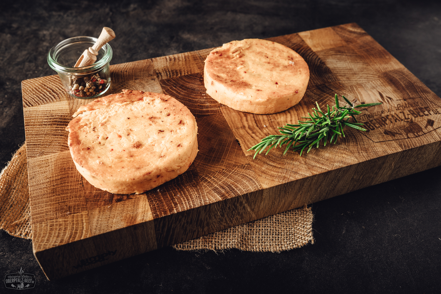 Gegrillter Käse mit Peppadew – Vegetarische Grillalternative aus der Oberpfalz Grillkäse mit Chili in rechteckiger Form, goldbraun gegrillt, mit sichtbaren roten Chilistückchen auf der Oberfläche, serviert auf einem dunklen Holzteller mit frischen Kräutern garniert – ideal für vegetarisches Grillen und scharfes BBQ.