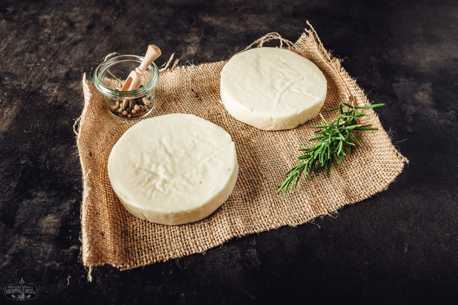 Grillkäse Classic auf Holzbrett mit Kräutern und Paprika dekoriert, ideal für sommerliche Grillabende und vegetarische Barbecues.