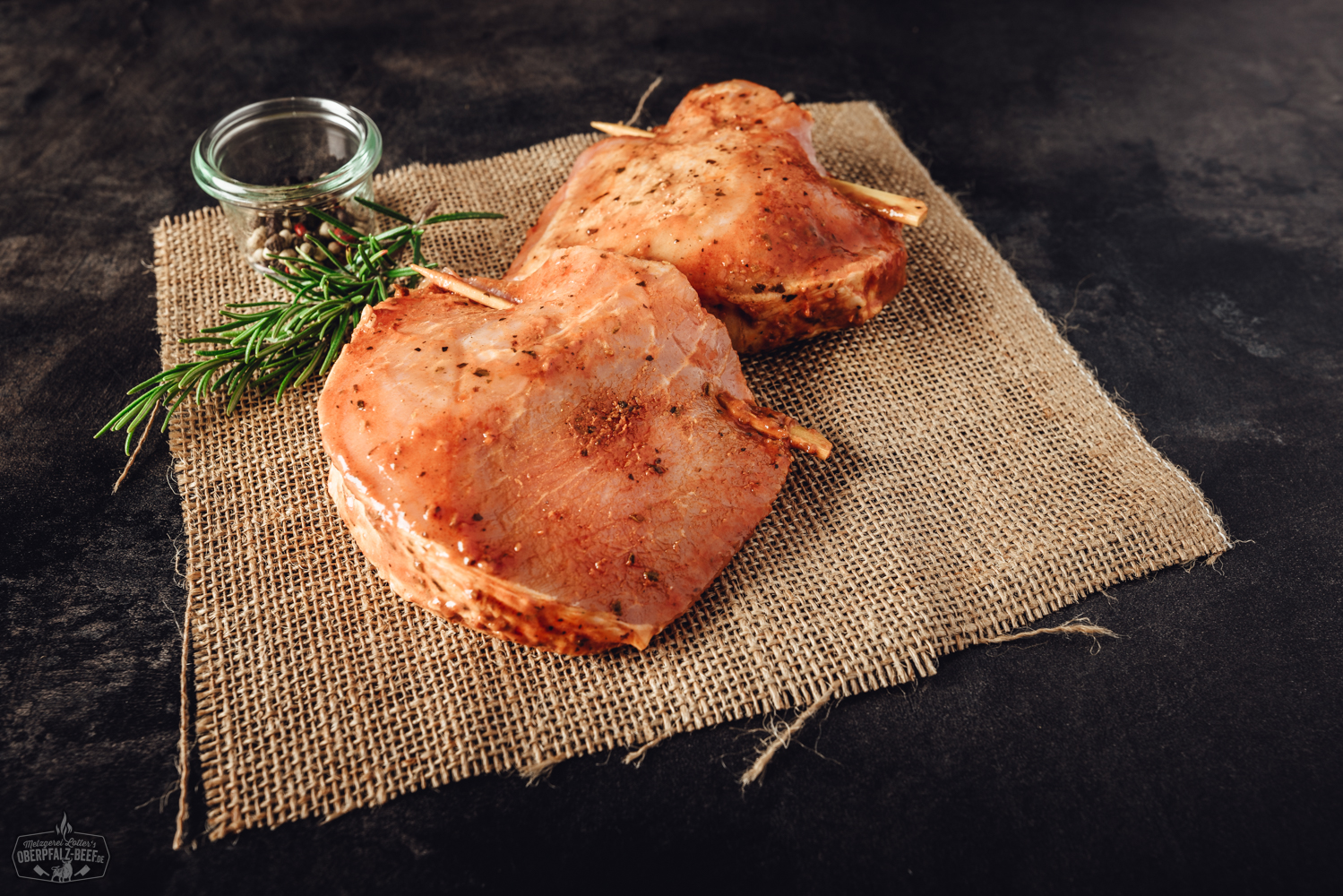 Gegrillte Schweinebauch-Fackel-Spieße auf Holzbrett angerichtet, goldbraun geröstet mit sichtbarer Würzung, serviert mit frischen Kräutern – hochwertiges Grillfleisch vom Schwein, typisch für regionale BBQ-Spezialitäten.