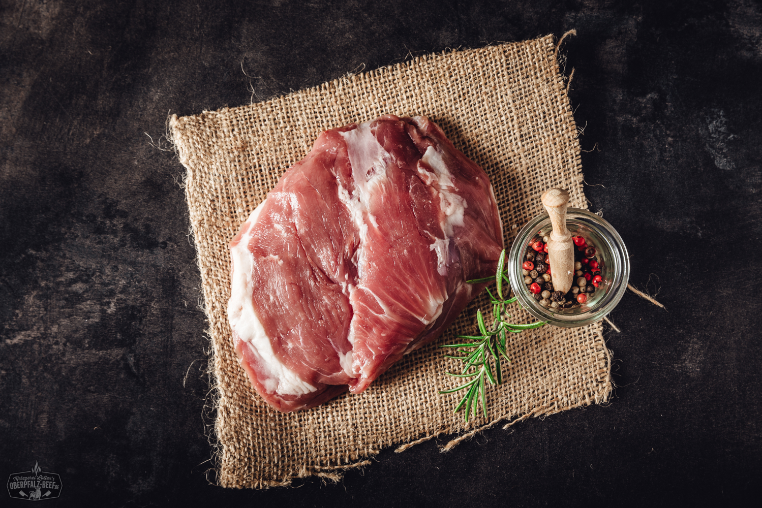 Lammhüfte vom Juradistl-Lamm – Regionales Premiumfleisch aus der Oberpfalz Pulled Chicken auf einem dunklen Teller angerichtet, saftige, zarte Hähnchenfasern mit würziger Marinade, serviert mit Petersilie und Limettenscheiben, rustikale Holzoberfläche im Hintergrund – traditionelle bayerische Küche, ideal für BBQ und Sandwiches.