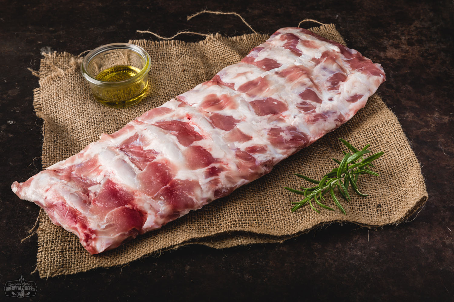 Zarte Kalbsrippen vom Oberpfälzer Milchkalb frisch gegrillt Saftig gegrillte Rippchen vom Oberpfälzer Milchkalb auf Holzbrett angerichtet, mit knuspriger Kruste, frischen Kräutern garniert und in rustikalem Umfeld serviert – hochwertiges Kalbfleisch für BBQ-Liebhaber.