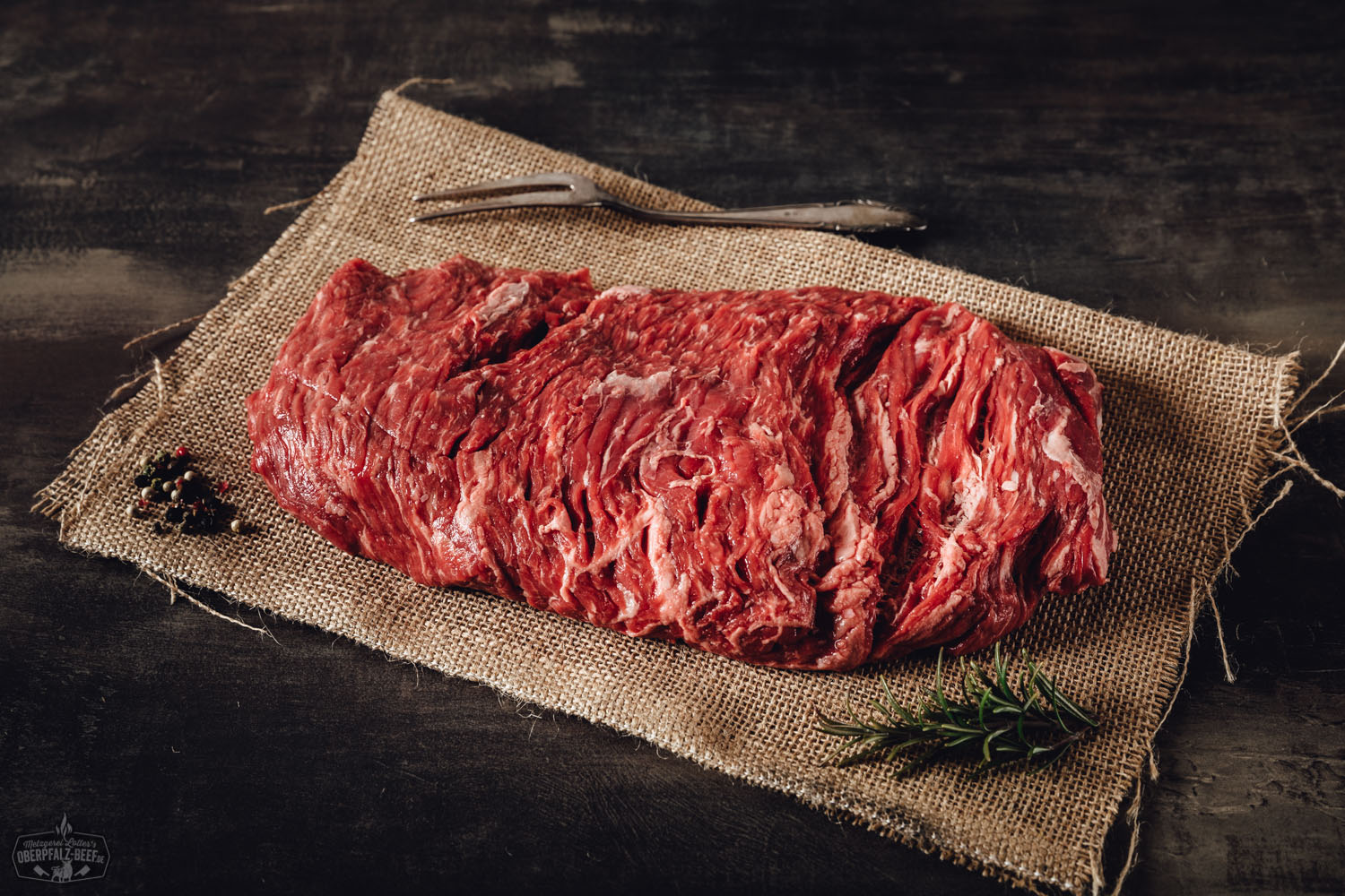 Rohes Bavette-Steak vom Oberpfalz-Rind, Wet-Aged gereift, auf schwarzem Untergrund angerichtet, mit sichtbarer feiner Marmorierung und angeschnittenem Randstück – hochwertiges Rindfleisch für Steak-Liebhaber.