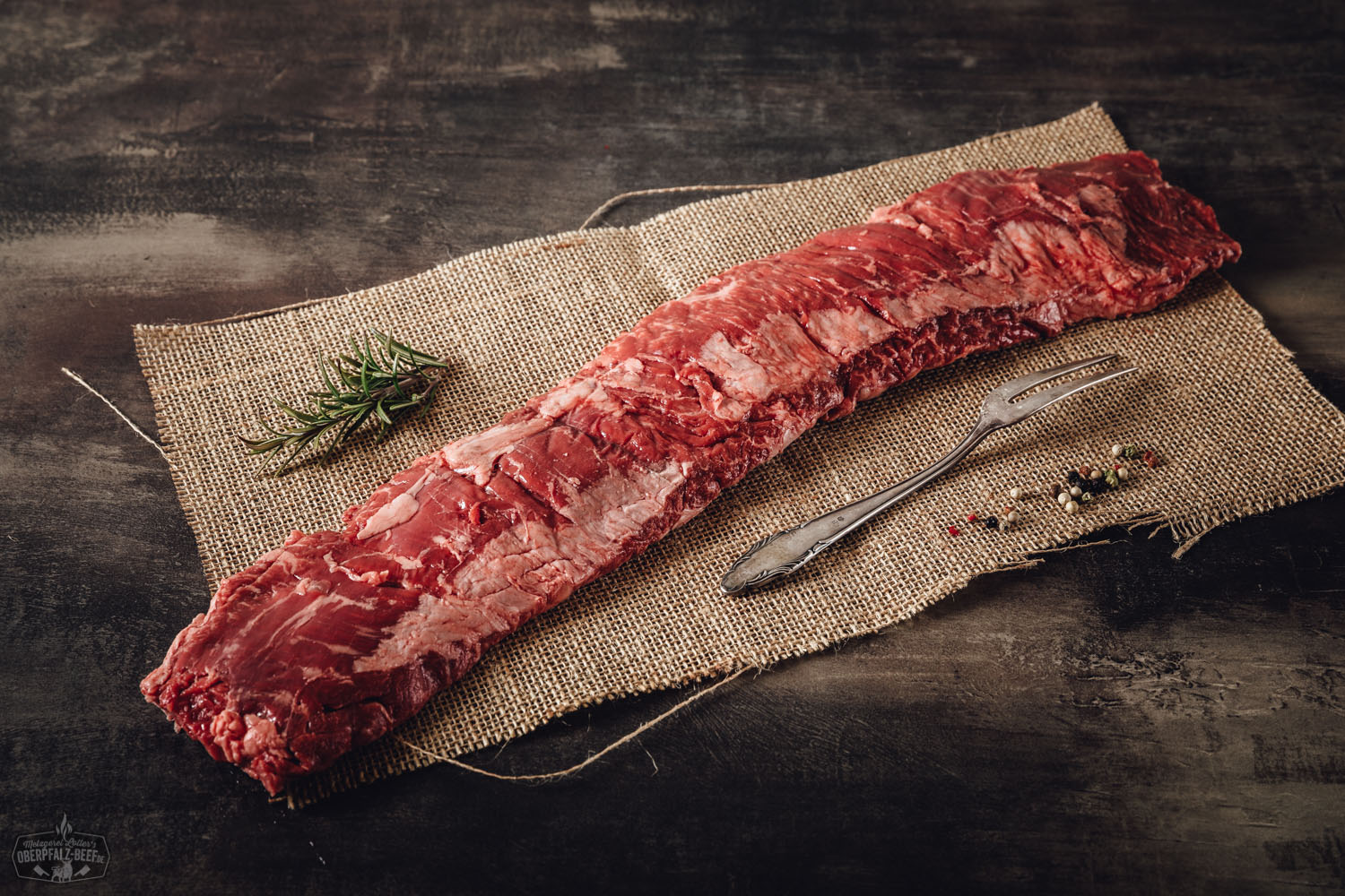 Outside Skirt Wet Aged vom Oberpfalz-Rind – Premium Rindfleisch kaufen Rohes Outside Skirt Steak vom Oberpfalz-Rind auf schwarzem Untergrund, angeschnitten, mit sichtbarer Marmorierung und frischer röter Farbe – hochwertiges, wet-aged Premium-Rindfleisch aus regionaler Zucht.
