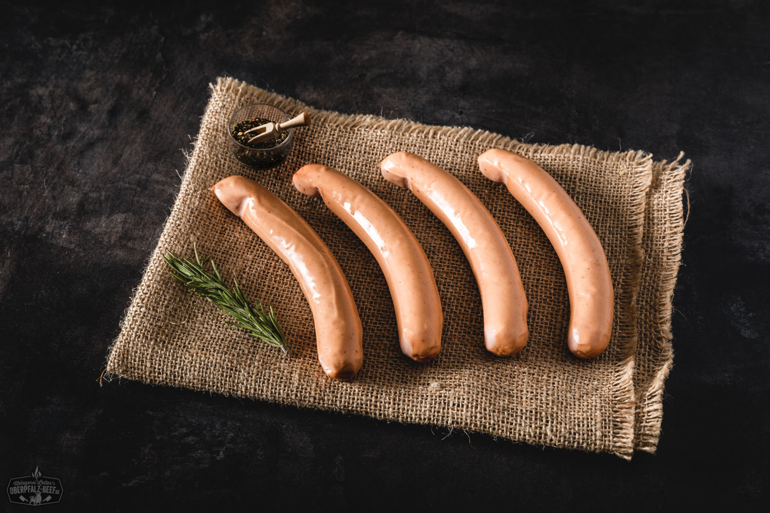 Wiener Würstchen auf Holzbrett mit Senf und Brot – Traditionelle Delikatesse aus der Oberpfalz Zwei goldbraun gebratene Wiener Würstchen liegen nebeneinander auf einem weißen Teller, begleitet von Senf und zwei knusprigen Brötchenhälften; im Hintergrund Holztisch-Oberfläche – klassische Brotzeit mit Fokus auf deftige Wurst aus der Oberpfalz.