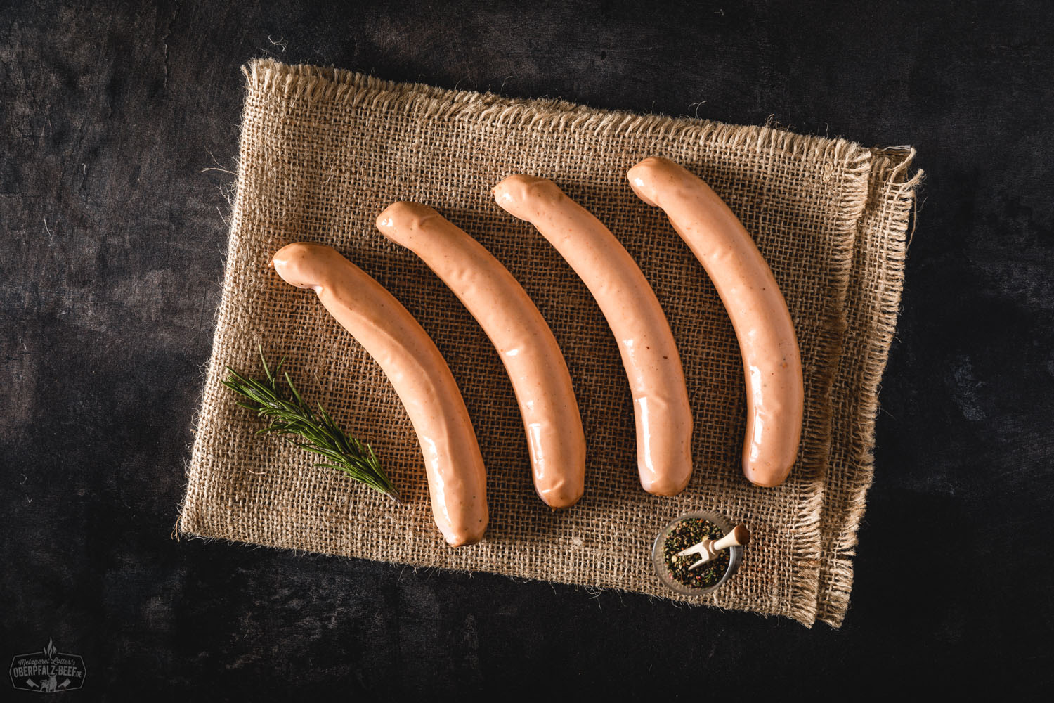 Wiener Würstchen auf Holzbrett mit Senf und Brot – Traditionelle Delikatesse aus der Oberpfalz Zwei goldbraun gebratene Wiener Würstchen liegen nebeneinander auf einem weißen Teller, begleitet von Senf und zwei knusprigen Brötchenhälften; im Hintergrund Holztisch-Oberfläche – klassische Brotzeit mit Fokus auf deftige Wurst aus der Oberpfalz.