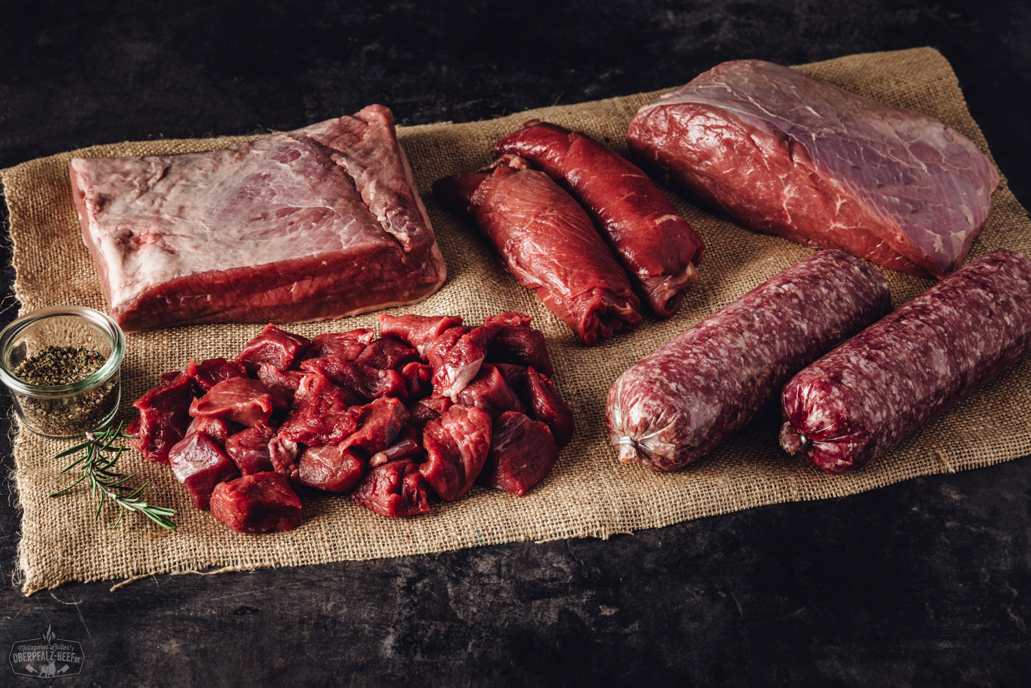 Frisch verpacktes Rindfleisch aus artgerechter Haltung in nachhaltiger Bauernhof-Box auf Holztisch, mit Etiketten für Herkunft und Qualität – regionale Fleischprodukte direkt vom Erzeuger.