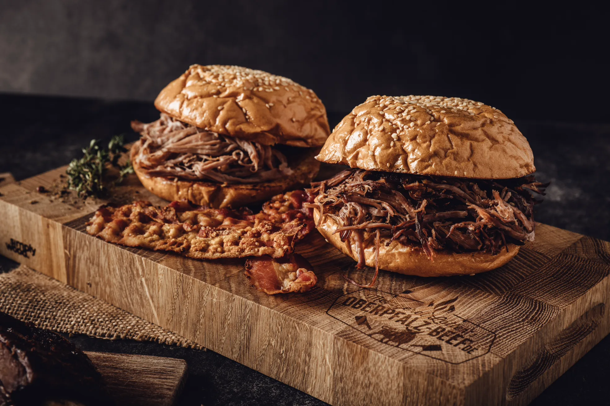 Frisch gegrilltes Oberpfalz Beef Steak auf einem Holzbrett, saftig durchzogen, mit Grillstreifen und Rosmarin garniert, im Hintergrund Glut und rauchige BBQ-Atmosphäre – hochwertiges Rindfleisch vom regionalen Metzger in Bayern.