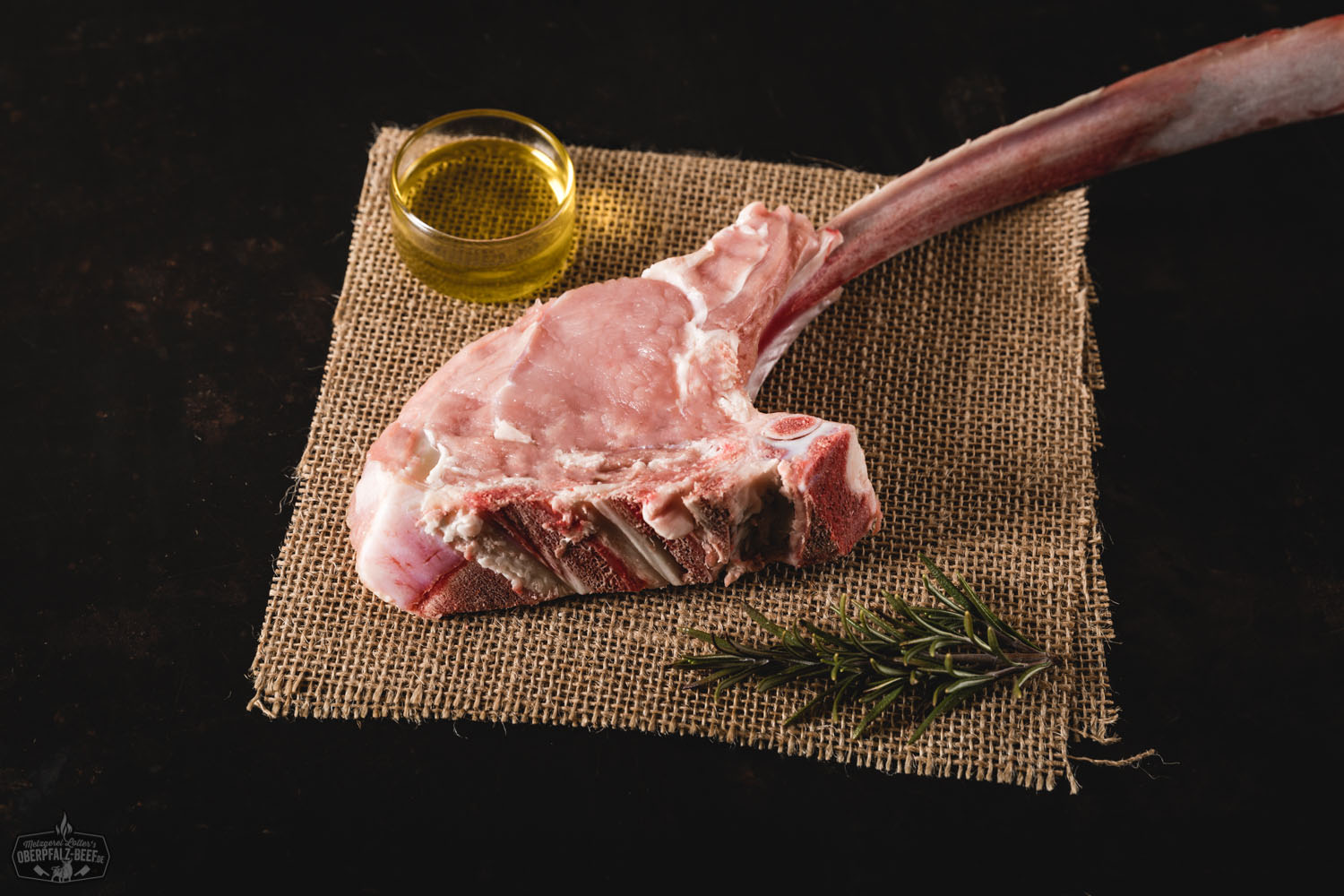 Tomahawk-Steak vom Oberpfälzer Milchkalb – Dry Aged Fleischspezialität Tomahawksteak vom Oberpfälzer Milchkalb, dry aged, saftig und zart, verführerisch im Bild präsentiert auf einem Holzbrett.