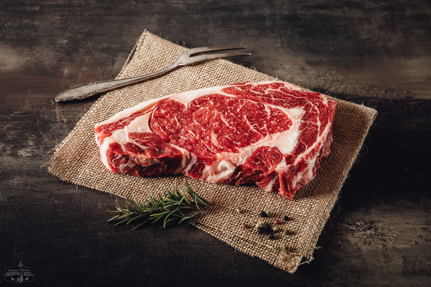 Rohes Entrecôte am Stück vom Oberpfalz-Rind auf dunklem Untergrund, gut marmoriert mit feinen Fettäderchen, frisch und vakuumverpackt für Wet-Aging; hochwertiges Fleisch aus der Region Oberpfalz.