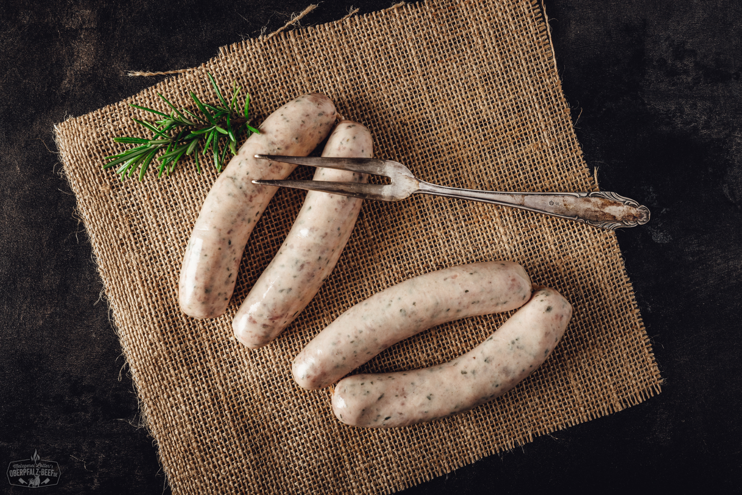 Bärlauchbratwürste frisch gegrillt auf Holzbrett – regionale Delikatesse aus der Oberpfalz Drei gebratene Bärlauchbratwürste liegen auf einem Holzbrett, angerichtet mit frischem Bärlauch, grobem Salz und Pfefferkörnern – Nahaufnahme unter natürlichem Licht, typisch für regionale Oberpfälzer Spezialitäten.