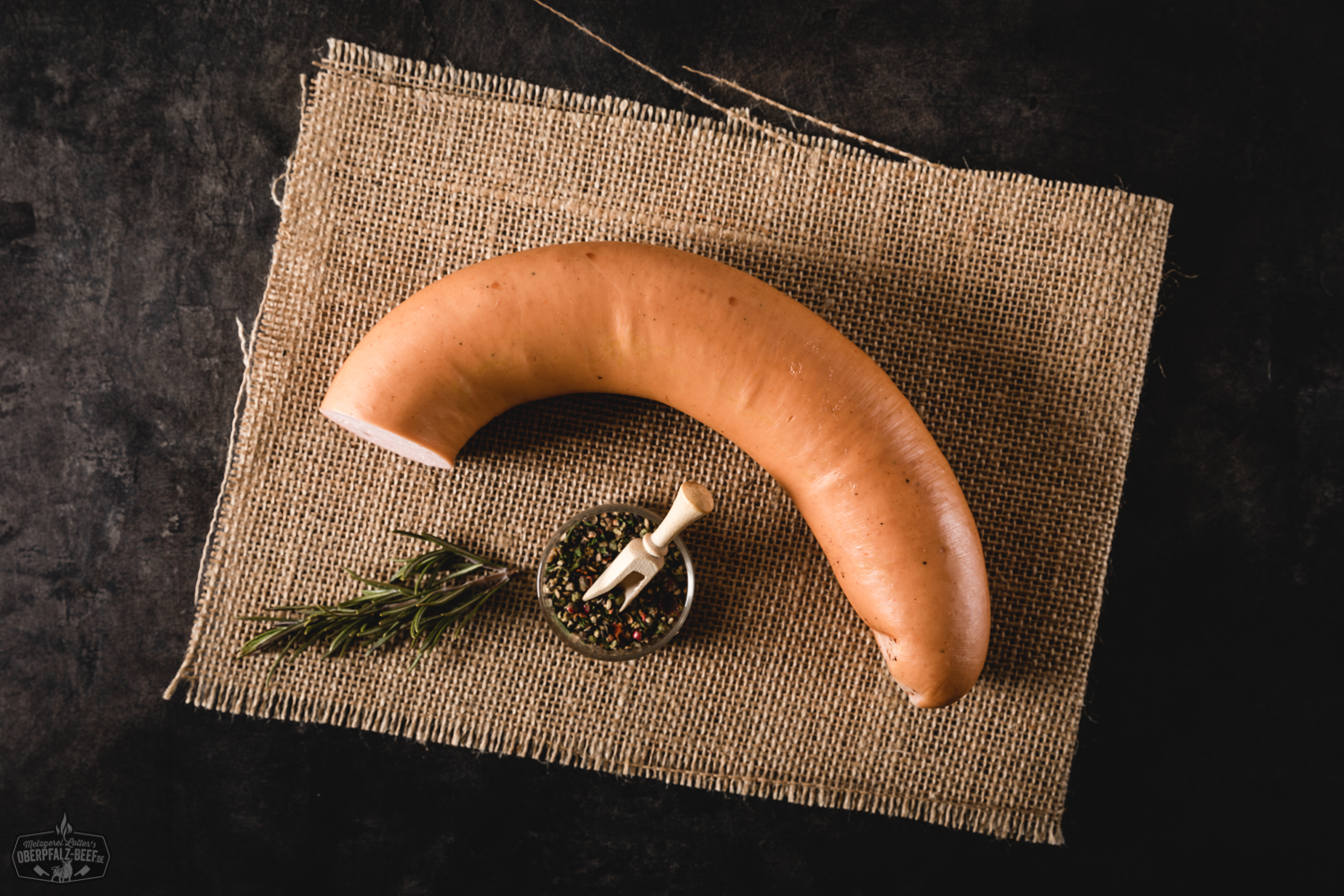 Wurstsalatwurst am Stück auf einem Schneidebrett aus Holz, perfekt für die Zubereitung von herzhaftem Wurstsalat, nahe Ansicht, ideal für traditionelle bayrische Küche