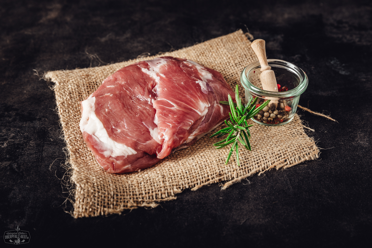 Lammhüfte vom Juradistl-Lamm – Regionales Premiumfleisch aus der Oberpfalz Pulled Chicken auf einem dunklen Teller angerichtet, saftige, zarte Hähnchenfasern mit würziger Marinade, serviert mit Petersilie und Limettenscheiben, rustikale Holzoberfläche im Hintergrund – traditionelle bayerische Küche, ideal für BBQ und Sandwiches.